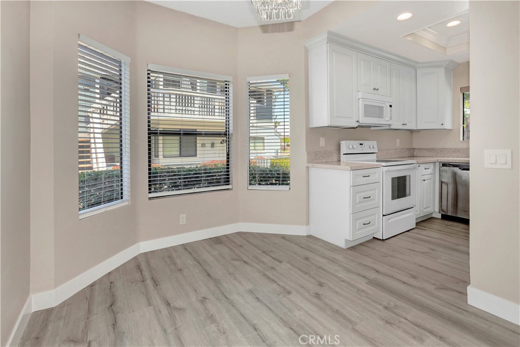 REMODELED, UPDATED, DARLING, LIGHT and BRIGHT! Lower unit, ONE LEVEL condo - Large living room open to dining room with beautiful crystal chandelier, lots of windows, custom cordless blinds, adjacent the brand new kitchen! Brand new kitchen - soft close cabinets and drawers, corner lazy susan, recessed lighting, luxury vinyl plank throughout unit. Freshly painted, new baseboards - just lovely home! HOA SCHEDULING TRACT TO BE PAINTED THIS YEAR. Mirrored hallway leads to 2 bedrooms - master features walk-in closet with shelving for storage, connecting bathroom with vanity then private shower over tub with commode. Second bedroom features sliding wardrobe doors, en suite shower over tub, vanity, newer fixtures. The new luxury vinyl plank is also waterproof, easy clean, current designer paint palette! Front patio with little garden, very sweet and relaxing. Lots of trees surrounding, lush landscape - very tranquil. While front door faces the Roosevelt street, it's set back with greenbelts and 2 sidewalks facing just a country road, not a thoroughfare, so is nice and tranquil. Around the corner building is a shared 2-car garage - this unit has 1 parking spot, in a 2-car shared garage. No pets please, kindly don't ask.