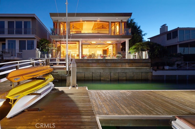 This ultra-luxurious, California-Contemporary Style, Lido Isle bayfront home is one of the finest in Newport Harbor. Rebuilt in 2002, in a collaboration between its owner’s and uber-architect Brion Jeannette, the home features spectacular water views of the Lido Channel, site of sailing races, morning crew workouts and all day harbor activity, and nighttime city light views of Fashion Island. The homes lower level has a thoughtful floor plan and features a huge great room with floor to ceiling retracting doors, high coffered ceilings, a limestone fireplace, a formal dining area, an elevator, a powder bath and a big island kitchen with stainless steel appliances, wine refrigerator and every thinkable amenity. Upstairs there is a gracious master suite with a limestone fireplace , an elegant bath and his and hers closets; in addition, there are two bedrooms with ensuite baths and a large bonus area that can be an office, bunkroom or play area with its own bathroom. The stunning palette of finish materials includes Honduran Mahogany, Walker Zanger stonework, honed Travertine, Granite, Limestone, pewter, stainless steel and tumbled Elk Mountain stone. The property features 45’ of bayfrontage and a private pier and dock that can accommodate an 80’ yacht and a side tie. Lido Isle is a resort community with a private Yacht Club, Tennis Courts, bay beach and activities for children to adults.