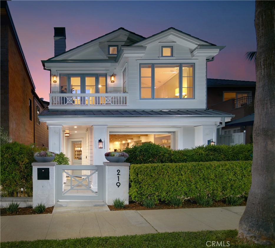 Nestled in the heart of CDM Village on the premiere 200 block of coveted Goldenrod Avenue, with its pedestrian bridge and location steps away from picturesque beaches, this contemporary Cape Cod-inspired custom home offers sublime ocean views from a variety of indoor and outdoor living areas. Crafted by Patterson Custom Homes, the three-level residence welcomes fresh sea breezes and abundant natural light through a series of hideaway glass pocket and accordion doors. A private front patio features a peek of the ocean, while a rear second-level balcony is shared by two bedrooms and overlooks the ocean, the yacht channel, and Newport Harbor. The primary suite offers ocean views from one of its two balconies, and the third-level entertainment lounge opens to a rooftop deck with panoramic ocean, harbor, city-light, and Catalina Island vistas. A skylight illuminates the staircase, and a Waupaca elevator accesses all levels. Opening to a private courtyard, the main floor presents a great room with dining area, fireplace, and built-in cabinetry with open shelving, while a chef-caliber kitchen is embellished with an island, quartz countertops, white Shaker cabinetry, under-counter wine storage, a walk-in pantry, and high-end Wolf and Sub-Zero appliances. Measuring approximately 3,440 square feet, the generously proportioned design features three en suite bedrooms and four-and-one-half baths. All bedrooms and a loft are located on the second floor, including the luxurious primary suite with fireplace, sitting area, walk-in closet with custom built-ins, a freestanding tub, two sinks, and a multi-head rain shower. Fun for all awaits on the top floor, where the lounge includes a generous bar with beverage center and freezer drawers, a full bathroom with indoor/outdoor shower, and a large outdoor deck with a fireplace and built-in BBQ. Additional highlights include a two-car garage plus carport and Savant Home Automation. Big and Little Corona beaches are minutes from home, and village shops and restaurants are close by.
