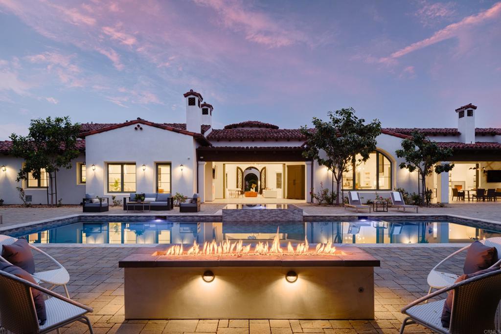 Experience luxury living in this stunning custom-built modern home, set on over 1.5 acres of meticulously landscaped private grounds in the exclusive Santaluz community. This residence epitomizes sophisticated living, designed for comfort and grand entertaining. Enter through a charming courtyard to an expansive open floor plan that blends elegance and functionality. The heart of the home is the deluxe kitchen, featuring a massive quartz island, top-of-the-line appliances, and upgraded countertops. This culinary haven seamlessly connects to an oversized nook and spacious family room, both flowing gracefully to the stunning outdoor areas. The kitchen also includes a state-of-the-art refrigerator and freezer, with a water softener in the garage. Exceptional amenities include a fully equipped indoor sports court with custom soft flooring, basketball hoops, a performance stage, and locker rooms. This versatile space can transform into a 16-car garage, ballroom, or premier entertainment area. Host unforgettable gatherings in the fully equipped sports bar with a wine room and enjoy movie nights in the luxurious home theater, featuring a 14.5' x 8' screen. The backyard is a golf enthusiast’s dream with a putting green, tee boxes, and artificial turf designed by Back Nine Greens. The stunning saltwater pool, adorned with Pebble Tec lining and glass mosaic tiling, includes water features and a large infinity spa, creating a serene oasis for relaxation. This custom-built masterpiece in Santaluz offers an unparalleled lifestyle in one of San Diego's most prestigious communities.
