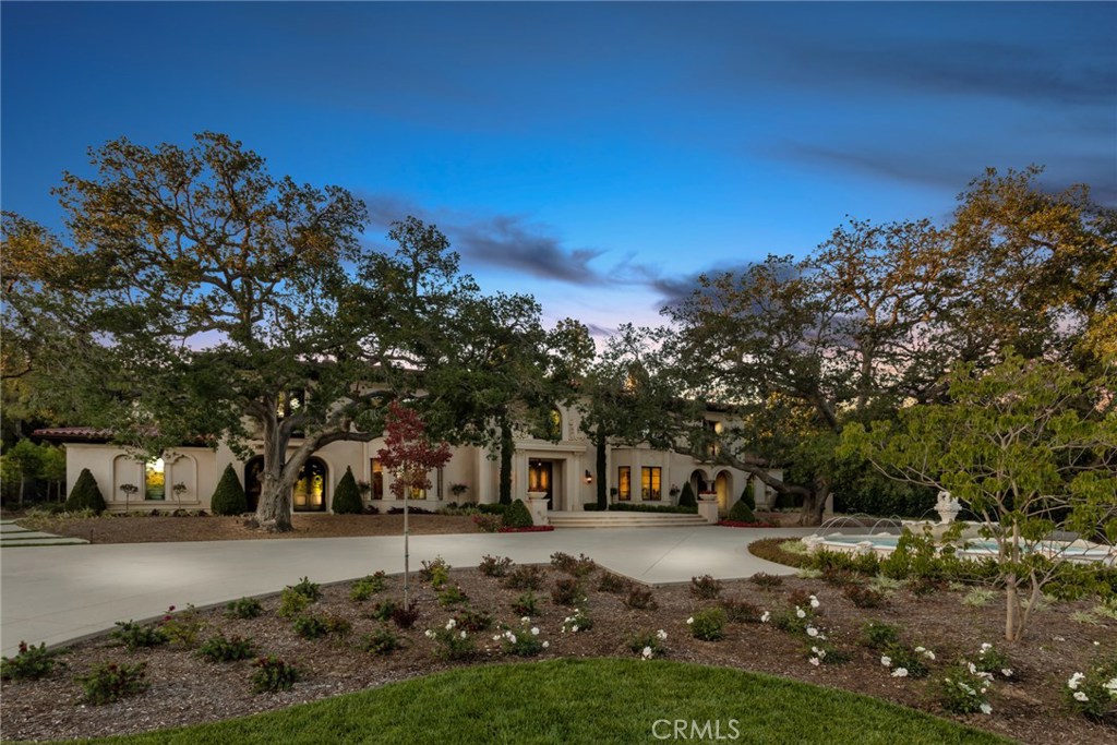 Crown jewel of North Arcadia - a spectacular, stately estate home located in prestigious Arcadia. This magnificent home sits on the south facing side of Singing Wood Drive. The large lot with mature oak trees frame the front of this elegant home. Beautiful landscaping and a circular driveway surround the home while a fountain anchors the front entrance. The large entry with wrought iron front door leads into the custom white marble foyer with a high ceiling. A gorgeous chandelier centers the foyer and includes a custom double staircase with wrought iron railing and custom hand-painted cove ceiling. The foyer adjoins the formal dining room/living room and leads into the large family room with extra high-ceilings. The family room looks upon a tranquil backyard with a glistening pool. An amazing marble kitchen with two extra large islands and an additional back kitchen with commercial appliances is adjacent to the family room. This magnificent home has two wings: the west wing for entertainment with a theater and study on the first floor, while the east wing has 3 spacious bedroom suites and a study. A large landing on top of the double stair case has a sitting area with skylight. In the west wing, an extra sitting area accompanies a wet bar, gym and 3 large bedroom suites. The master suite takes up the entire east wing. The master suite has its own sitting room, bathroom with roman tub, his & her showers, and a massive walk in closet. Custom wood paneling throughout the home.