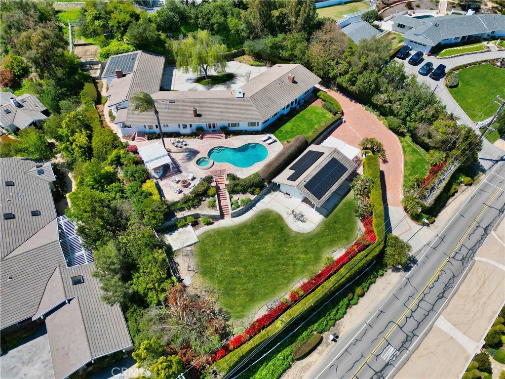 Perched at the top of a private gated entry, overlooking panoramic city light and mountain views sits a breathtaking 1.3 acre property in the beautiful gated city of Rolling Hills. As soon as you make your way up the circular driveway you are greeted by a one-level ranch style home featuring 5 bedrooms, 6 bathrooms. The heart of the home can be found in the great room, including a stunning living room with fireplace with views from every window of the mountains and city, formal dining room and gourmet kitchen with Sub Zero and Wolf appliances plus a huge walk-in pantry. Enjoy movie night in the cozy family room with wet bar and walk-in liquor pantry, this makes for a perfect space to entertain your guests. The incredibly spacious master bedroom includes a walk in closet, plus bathroom and a private outdoor deck to enjoy the morning sunrise. Highlights include stunning wood beam ceilings throughout, HEPA filtration system in the bedrooms, 5 a/c and heating zones, solar heating for the pool, a beautiful private temperature controlled wine cellar down a romantic spiral staircase, plus an oversized 3-car garage with storage. Take a step outside to the entertainers dream backyard with sparkling salt water pool and spa, outdoor kitchen with bbq, outdoor bathroom with shower, firepit, barn, plus a huge sprawling grass lawn all overlooking stunning views of the Los Angeles Basin and mountains.