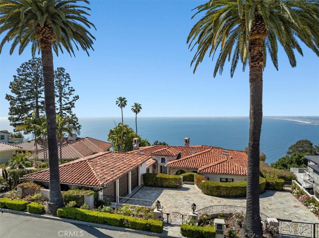 Live on top of the world while looking over the iconic Los Angeles Coastline! This custom built Tuscan Villa has 4 bedrooms plus office, 5.5 baths and offers one of the most stunning Queen's Necklace and sunset views on the Palos Verdes Peninsula. As you step into the formal entryway you are welcomed with breathtaking ocean views, high ceilings, and an open floor plan that flows effortlessly through the grand living room, dining room, family room, and kitchen. The large gourmet kitchen is perfect for entertaining and features two large islands, Viking appliances consisting of three ovens, a built-in Microwave, two Dishwashers, warming / chilling drawers, a Subzero refrigerator and freezer, and a Miele espresso maker. Enjoy sweeping ocean and city views from all living spaces and balconies off the formal living room and breakfast areas. The luxurious and spacious primary suite has incredible views with a huge en-suite complete with a large shower, separate steam room, dual walk-in closets, double sinks, and a spa tub. The game room / family room below overlooks the entire bay and leads to the pool and backyard through massive french doors. The backyard is an entertainer's dream and features a resort-like infinity edge pool with hot tub, an outdoor kitchen with Viking stainless steel appliances, and multiple observation areas to enjoy the extraordinary views. Other amenities include an 800-bottle capacity wine cellar, an elevator, hardwood and natural stone flooring throughout, a built-in bar including Viking refrigerator and ice-maker, multiple custom stone fireplaces, heating and air conditioning systems, and massive indoor storage for decorations and equipment. The enlarged 3 car garage with epoxy floors is perfect to store classic or luxury cars with the privacy of an electric gate in front of the spacious driveway. This resort-like home is situated mid block on a cul-de-sac street and offers a World of Paradise!