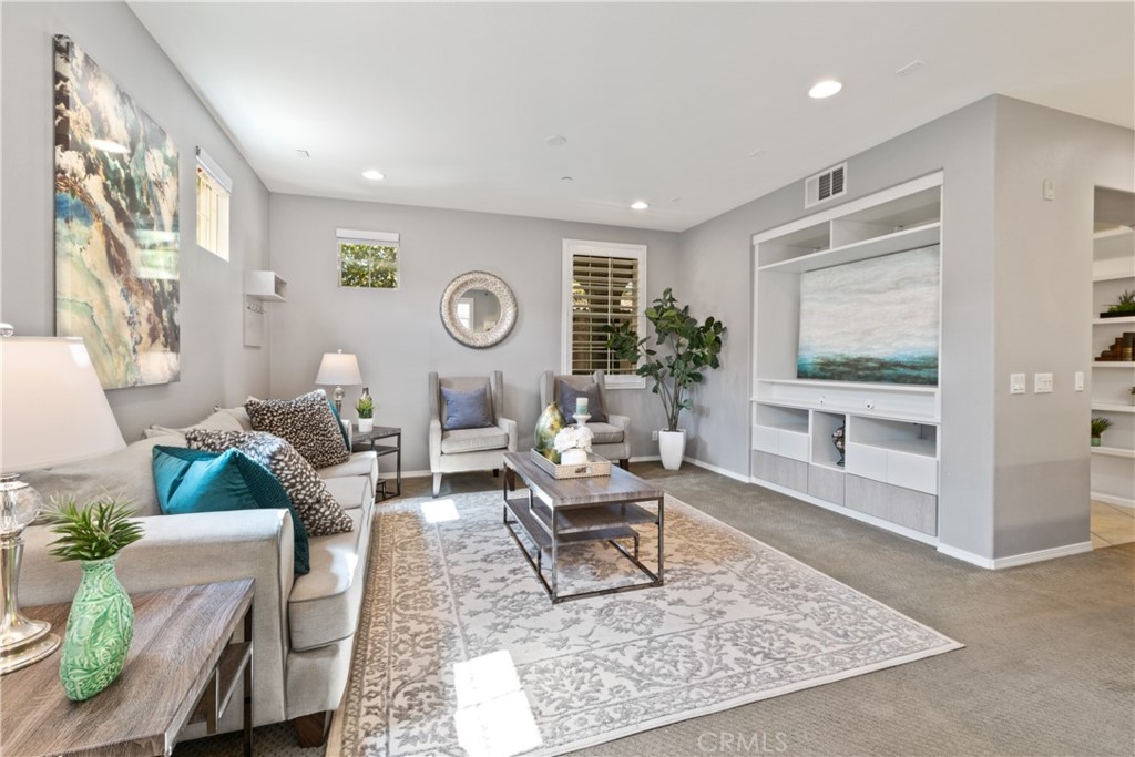 Welcome to San Carlos located in the beautiful village of Portola Springs. This single level, end unit condo shows light and bright, with a tastefully upgraded open concept floorplan. The kitchen includes granite countertops, custom backsplash, stainless steel appliances, recessed lights and breakfast bar that opens to both the dining and living areas. The living space's high ceiling makes it feel extra spacious and a custom built-in entertainment center provides additional display and storage space. The dining area includes large windows, plantation shutters and is perfect for casual meals or entertaining. The primary bedroom boasts high ceilings and large windows allowing for plenty of light. The stylish ensuite bath includes a dual sink vanity with an abundance of storage, updated tub/shower with gorgeous tile work, large walk-in closet and custom barn door for privacy. The cozy second bedroom, originally a den, has a well organized custom closet with mirrored wardrobe doors and fun, stylish light fixture. The full sized laundry room makes laundry chores a breeze. The private front patio is the perfect spot to relax and enjoy the greenbelt view of the neighborhood. Association amenities include resort like pools, spas, parks, tennis and sport courts. Top rated IUSD schools. Conveniently located to entertainment, dining, shopping and easy access to freeways and toll road.