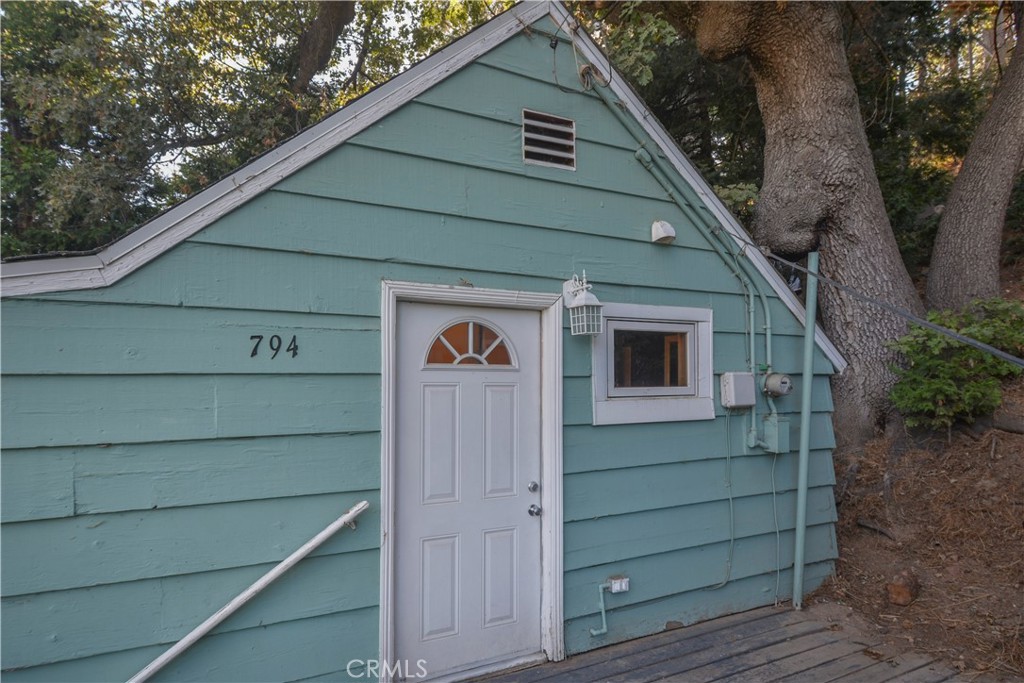 Perched above the soaring treetops, this cozy little cabin in the woods, gives you the "Treehouse" Vibes. One bedroom and one bathroom, with a fireplace to keep you warm for those winter months. Spacious, open kitchen. Matching shed for extra storage. Washer and dryer hook-ups. Close proximity to the main highways and the village. Don't miss this great opportunity, to own a home in beautiful Lake Arrowhead. Located in Arrowhead Villas with a yearly assessment, which includes services: trash collection, road repair, snow plow, & water.