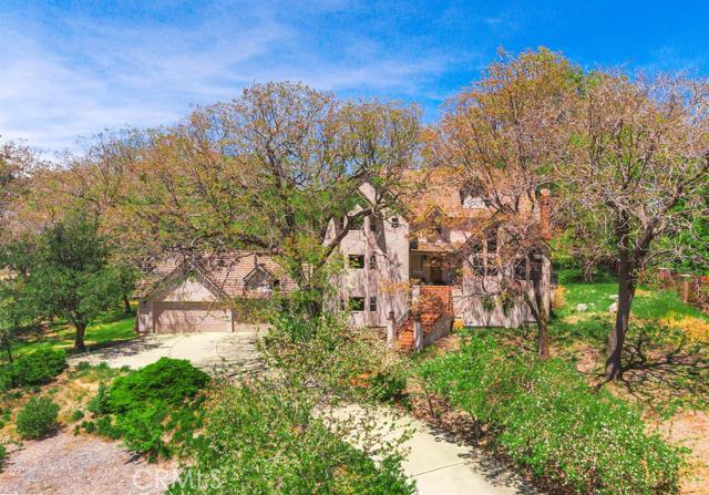 Located on a cul de sac and centered on 1.2 acres, this custom high end Ron Dolman built estate offers a peaceful setting within a grove of tall oak trees. Zoned equestrian, 4 beds, 3.5 baths, and a study with attached full bath. Quality crafted wood beams throughout and a total of 4 fireplaces. Vaulted ceiling living room, + game room/den. Master suite with large walk in closet, fireplace, and hand carved beamed ceilings. Updated kitchen offers stainless appliances, plenty of counter space and cabinet storage. 3 car garage with mud room upon house entry. Large rear deck overlooking a massive nearly level backyard perfect for kids. A short walk to National Forest trails for hiking, off road vehicles, and horseback riding. This property is a must see for those looking for a serene estate setting, with plenty of room for the family!