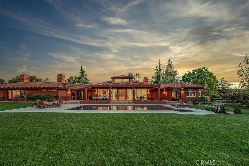 Perched on over 227 lush acres of land in the Williamson Act, this luxurious estate offers a tranquil retreat unlike any other. Beyond the privately gated entrance, discover a custom-built single-level masterpiece boasting 5 bedrooms and 5.5 bathrooms, each thoughtfully designed with their own lavish en-suites.
Spanning over 7,100 sf, the residence is adorned with Saltillo tile floors throughout, complemented by extraordinary custom mahogany and black walnut doors, cabinets, and baseboards showcasing a level of craftsmanship not often found today. The grandeur of this home is further accentuated by cathedral ceilings with clerestory windows, skylights, and a floor-to-ceiling wall of glass framing panoramic views of vineyards and rolling hills.
Entertain with ease in the open-concept floor plan featuring a family room, living room, formal dining room, and a custom solid mahogany wet bar. A media room/den equipped with automatic blackout curtains adds a touch of cinematic luxury.
Experience seamless indoor-outdoor living with glass doors opening from nearly every bedroom to the extensive back patio, where an in-ground pool and spa await amidst sweeping views. The primary suite features two opulent walk-in closets with floor-to-ceiling custom built-ins, a spa-like bathroom, and a double-sided fireplace connecting to an adjoining sitting room or meditation space.
The heart of the home is the expansive chef's kitchen, featuring professional-grade Viking appliances. A center island with bar seating along with the bright and sunny second dining area create space perfect for gatherings. Nearby you’ll find a walk-in pantry, laundry room, and access to the immaculate 3-car garage.
For those with a penchant for hobbies or business ventures, a 4,000 sf airplane hangar with 3/4 bath showcases an area large enough for a full gym and large workshop with an additional loft for an office or storage. A separate building with a 2-car garage, additional workshop/storage space, and nearby RV parking adds to the property's versatility.
Additionally, a 2-bedroom, 1-bath manufactured home with a separate gated entrance provides the perfect retreat for guests or groundskeeper's quarters.
Indulge in the ultimate luxury lifestyle at this exceptional estate located just a few minutes from downtown Templeton, where every detail has been thoughtfully curated to exceed expectations.