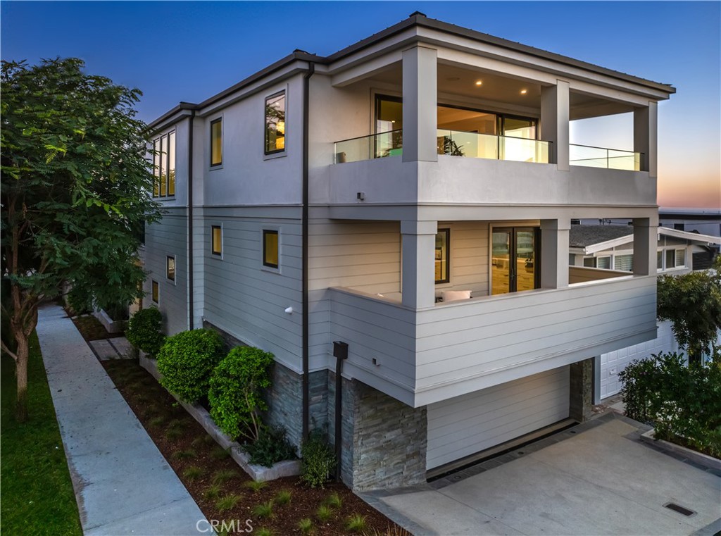 Welcome to 1215 Fisher Avenue, a beautiful Coastal Modern residence, custom built in 2019 on an ideal corner lot in a location central to downtown shops and restaurants as well as the Strand. Featuring five en suite bedrooms and six baths in 5400 square feet, this home offers every amenity. Experience the magic of living by the ocean in this thoughtfully designed layout ideal for entertaining, as well as features such as high ceilings, European white oak flooring throughout, and unending ocean views. Four levels of bright interiors include panoramic ocean views from the stunning, wide-open top floor, where the enchanting living room houses custom cabinetry, a bar, and a contemporary fireplace. The private terrace is accessed via glass pocket doors and provides seamless indoor/outdoor living with an idyllic place watch the sun set. A wall of windows along the dining area delivers a front-row view of the panoramic vistas from Palos Verdes to the Santa Monica mountains. Prepare your favorite dishes from the inspired Chef’s kitchen, which boasts a 12-foot Neolith island, a SubZero fridge and wine fridge, a 6-burner Wolf stove, a steam oven, a built-in Miele coffee station, and two Bosch dishwashers. A cozy family room with a fireplace and views to Palos Verdes is adjacent to a covered, heated outdoor dining terrace with Lynx barbecue. The designer-perfect powder room completes the showstopping top floor. Downstairs, the Primary suite beckons with its own fireplace, custom built ins, two custom walk-in closets, and an ocean-view terrace, as well as a striking spa-like bath with steam shower and soaking tub. Two additional en suite bedrooms (one with an ocean-view deck) and a convenient laundry room are nearby. The entry level includes a large family or game room with access to the private patio and yard (complete with outdoor shower), a well-appointed en suite guest bedroom, and access to the three-car garage. A media room with full-size wet bar, a wine storage room, and an office or fifth bedroom is found on the lower level. This home is technologically savvy and includes a security system with six cameras, Enterprise-grade WiFi, IP video, DoorBird video doorbell, three-zone HVAC system, and more, as well as a convenient four-stop elevator. Steps to the Greenbelt and tucked within the enchanting American Martyrs neighborhood, 1215 Fisher Avenue is an aspirational home for the discerning buyer in the heart of Manhattan Beach.