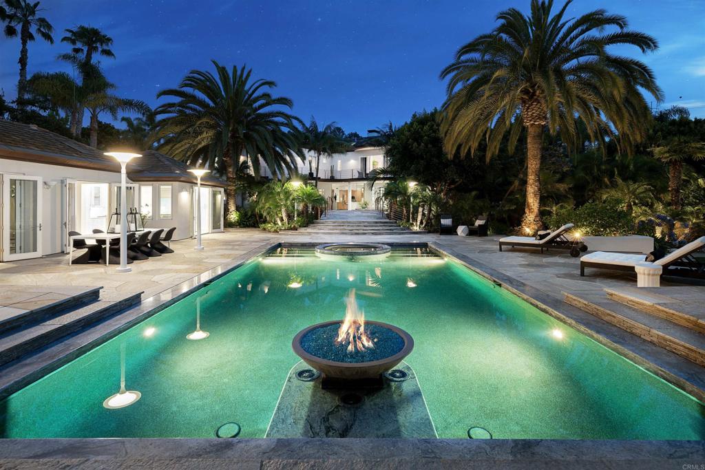 Peaceful Tranquility surrounds this contemporary architectural masterpiece encompassing a magical nearly two totally private acres, which is just a short 1.5 miles to the Pacific Ocean. This private compound includes the main residence, two detached guest houses, and a resort-style saltwater pool, which features fire and a stone waterfall, designed by the renowned Skip Phillips. The lighted tennis court is complete with a viewing pavilion. For the most discriminating clients, the entire compound is meticulously appointed and exudes world class elegance with unsurpassed craftsmanship throughout! The solar powered main residence features approximately 7K sqft with 5BR/5.5BA suites plus two guest houses, totaling approximately 9K sqft. The highest quality finishes are numerous and can only be appreciated in person! Some of which include a state-of-the-art smart home automation Creston System, wiring throughout for ethernet, surround sound, separate temperature controls for each room, designer curved walls & window walls, floor to ceiling glass doors, 24 x 24 limestone, granite flooring, numerous English Sycamore lacquer cabinets, Wolf ovens, 2 Sub-Zero full size refrigerator & freezer, plus 4 Sub-Zero refrigerator drawers, Sub-Zero Wine cooler, and 2 Miele dishwashers and espresso maker. Rain glass opens to the family/theatre complete with Creston wireless system. Sleep under the tropics of Kentia palms through the picture curved glass window in the master ensuite with French doors that open to your own private balcony overlooking the amazing, lush landscape. Enter the spacious bath complete with a rain shower/steam. Never leave the compound while enjoying the walking paths through the tropical oasis that you will call home. Lavish outdoor entertainment areas, complete with wood burning fireplace, Wolf BBQ, Evos, and seating for over 12.