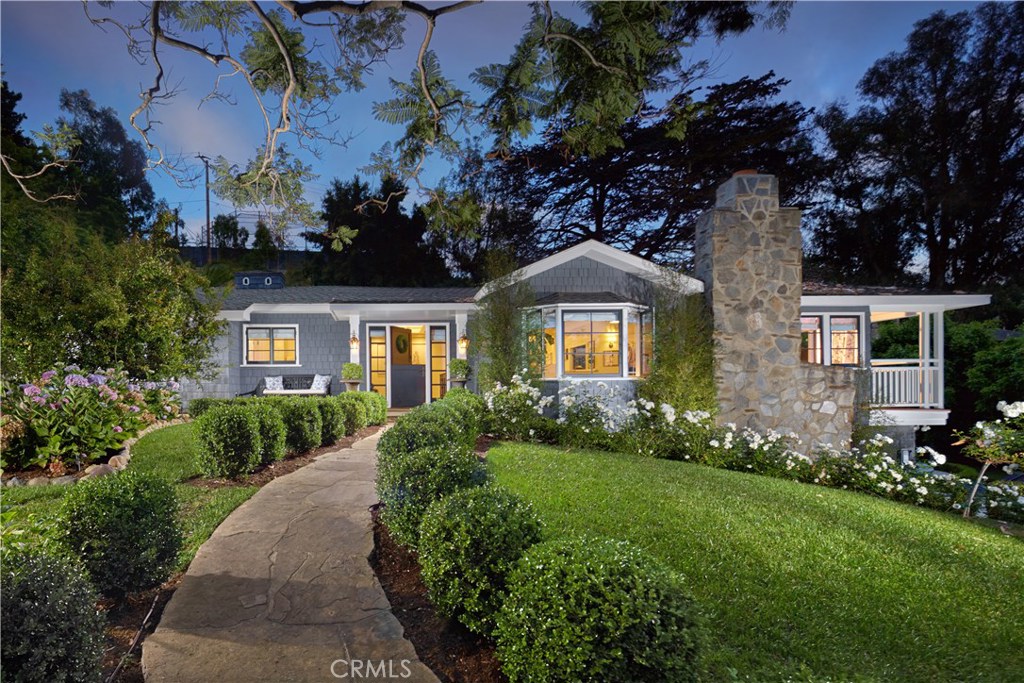Set on nearly one-acre in the heart of the Village is 495 Arroyo Chico – an enchanting 3-structure legacy estate steeped in local history dating more than a century. Tucked behind private gates at the base of a natural amphitheater (believed to be the original site of the Pageant of the Masters), the compound emanates conspicuous grandeur, achieved with unbridled privacy and luxurious accommodations complemented by time-honored elements including dozens of native trees, original paths and planters winding the property, and one of the largest pools in Laguna, rumored to be the former public pool whose steps rehabilitated World War II soldiers. While unequivocally significant in antiquity, the residence also boasts modern amenities and appointments in each of the main house, guest house, and media/pool house including a state-of-the-art kitchen, spacious bedrooms with ensuite baths, media/gaming room, Smart Home technology, and a Chiltern Firehouse-inspired bar fit with wine dispenser, ice maker, wine refrigerator and drawers. High-end finishes adorn each structure, among them Statuario Altissimo marble countertops, wide plank wood floors, custom windows and millwork. Additional highlights of the sprawling estate are a gas firepit, fruit trees, herb garden and the piece de resistance – an ethereal outdoor dining area beneath a canopy of 100-year-old wisteria. A rare offering of space, location, comfort and history – this distinctive estate is a once-in-a-lifetime opportunity.