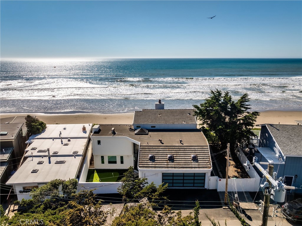Singular Site and Structure create a special opportunity to enjoy the experiences offered by broad beach, sweeping ocean vistas and a unique beach town. The unusual silhouette and wide parcel only hint at what’s beyond. Inside the front gate is a private space with morning sun ideal for many uses. A soaring wall of glass entry only hints at the unique interior plan. The garage level is a half floor above with a laundry area on the way. A huge family room with ocean views, big screen media display and space for many sitting options has a half bath near and to stairs to the great room. A game room is adjacent with its own stairs to the great room. Living, dining and kitchen all have stunning views, deck access and an elegant fireplace. A side yard has a fire pit and hot tub. A guest bedroom and bath are near. The primary suite occupies the upper level with panoramic views, deck access and an elegant bath. Private stairs to the beach include sitting areas and there’s an engineered seawall. The large yard area includes an undeveloped section for future plans. These spaces capture the essence of coastal living and provide for a range of use options to suit a variety of lifestyles and pursuits.
