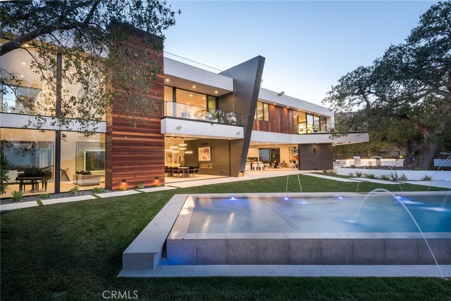 Your new custom contemporary masterpiece with panoramic views eagerly awaits your arrival. Gated and located at the end of the cul-de-sac, privacy is the utmost experience you become immersed in. The tremendous glass front door sweeps you through the expansive formal living and dining room. With 11ft. ceilings & disappearing glass pocket doors all throughout, your stride through this magical estate. The striking custom chef&#8217;s kitchen featuring luxurious custom Italian cabinets, top of the line appliances, & two grand center islands offers plenty of space for hosting friends and family. Continuing thru the magnificent main level, you will be amazed with the hi-tech home theater adjacent to the trendy bar, lovely office, & deluxe family room. Take your illuminating floating staircase upstairs to where the fantasy continues. The majestic master suite wing allures all who enter with two boasting walk-in closets, an extraordinary espresso bar, two fabulous balconies, a glorious master bathroom with a free-standing tub. Additional enchanting en-suite bedrooms designed with convenience in mind. The glamorous backyard radiates breathtaking views from every angle. Enjoy a morning cup of coffee on your wood deck while gazing at the lush greenery and end your evening soaking in the infinity pool & spa while wishing on the stars. Additional amenities include 2 BBQs with counter space, 1500sqft rooftop deck, 2nd floor family room, 3 car garage, Control 4 home automation, and so much more!
