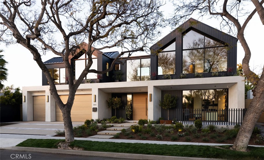 Step into an architectural masterpiece where every element of design invites you into a world of elegance and innovation. The journey begins at a double-height entry, framed by a grand custom oak archway, bringing to mind the tranquil water wall of the pool. Towering 16-foot privacy hedges guide your gaze inwards toward the expansive great room with kitchen and dining areas. Central to the home is a chef's kitchen featuring a Pitt cooktop and elite Gaggenau appliances that enhance the culinary experience, complemented by an island with fluted woodwork, masterfully placed Taj Mahal leather quartzite, and seamless custom oak cabinetry. A convenient automatic pass-through window connects to an outdoor eating area, beside a matching secondary full catering kitchen hidden behind custom-created fluted glass and steel archways. Here, in the heart of the home, additional majestic oak archways merge form and function seamlessly, centering the bar area and art walk behind.The contemporary design, envisioned by award-winning architect Eric Aust, enhances the neighborhood's charm with dramatic dormers, a lush full width living roof, expansive windows, and expert landscaping from Garden Studio. Within its striking exterior, the home features five ensuite bedrooms, five-and-a-half baths, plus an office and a separate loft, spanning 4,857 square feet of harmonious living space. The interior designed by Serendipte, blends luxury and comfort with white oak flooring, vaulted ceilings, and rich limestone and quartzite details, creating an upscale ambiance across two levels. The first-floor bedroom suite offers easy access to the office, which opens to a private front patio. Upstairs, additional bedrooms with private baths and a bonus room offer further living flexibility. The primary suite is a sanctuary with a massive walk-in closet, floating vanities, a freestanding tub, and an indulgent steam shower. Every detail speaks of handcrafted excellence, from wood-clad archways to mud in LED lighting and natural stone tiles by Ann Sacks and Walker Zanger. A three-car garage further provides function with two entry points one to the secondary kitchen and one to the mud room, with a laundry room located upstairs. Wrapped around this home is a lush backyard oasis with a custom pool, spa, 700 sqft California room, full outdoor kitchen, flush mount heat lamps, sound, fireplace and fire pit. This exclusive SkySail residence is destined to elevate your lifestyle for generations.