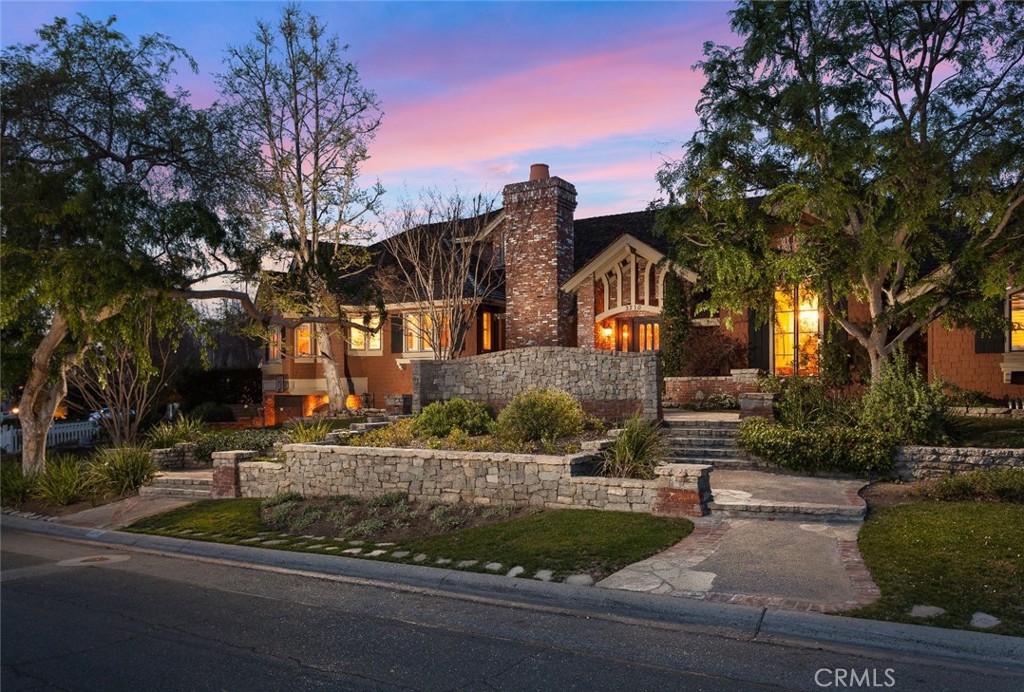 Welcome to 3210 Las Faldas Drive, a stunning Tudor-style estate that perfectly blends timeless elegance with modern luxury. Custom-built in 1995, this remarkable 6,023 square foot residence is situated on a beautifully landscaped lot, offering privacy, sophistication, and a true sense of grandeur.
Step inside and be captivated by the soaring 23-foot vaulted ceilings and impeccable finishes that define the home’s refined interior. With six spacious bedrooms and six luxurious bathrooms, this estate offers exceptional comfort and versatility for both everyday living and grand-scale entertaining. Each room is thoughtfully designed, showcasing meticulous craftsmanship, custom millwork, and designer details throughout.
The Tuscan inspired chef’s kitchen seamlessly flows into expansive living and dining areas, perfect for hosting gatherings. Large windows and French doors invite abundant natural light and open to the backyard oasis, creating an effortless indoor-outdoor living experience.
Escape to your private resort-style backyard, designed for relaxation and entertainment. Take a dip in the heated saltwater pool, unwind in the spa, or gather around the fire pit under the stars. The outdoor amenities continue with a built-in BBQ island, spacious patio for al fresco dining, shuffleboard court, and a built-in trampoline—perfect for creating unforgettable memories with family and friends.
This exceptional Tudor estate offers an unparalleled lifestyle in one of Fullerton’s most desirable neighborhoods. Don’t miss the opportunity to make this timeless masterpiece your forever home.