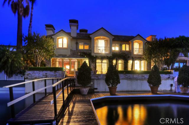 Stunning wide-water views to Fashion Island, comfortably and quintessentially Parisian, this expertly rendered waterfront garden manor on Lido Isle masterfully conveys France’s unique urban blend of Old World and Early Industrial charm. Rugged French and Colorado limestone of remarkable variety, copper-clad window planters, handsome slate shingle roofs, dining loggia, and the surrounding home’s trademark metal windows and doors plus assorted leaded glass artistry combine in an exquisite courtyard reminiscent of a Paris herb garden café. The approx. 6,700-sq ft 3-level home’s interior is architecturally rich yet fabulously refined in taste and scale. It has 4 ensuite bedrooms; 3 powder rooms; formal dining and bayside living/sitting rooms; large gourmet all cherry-wood kitchen with parquet floors and adjacent garden-side breakfast nook and den; paneled bayside library; elevator from an elegant, nearly 3000 sq. ft. subterranean 5+-car garage, temperature controlled wine cellar and tasting room; 2 laundries; and 2 bonus rooms. Second bayside patio overlooks boat dock for approx. 75 ft. vessel. Additional features include Lutron smart-house electrical system. Rare opportunity to be at the point end of Lido at the Turning Basin with unmatched views.