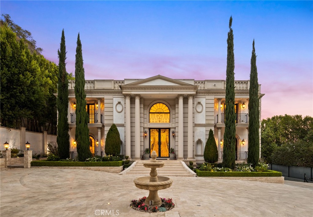 Privacy, luxury & leisure time are paramount on this stunning 4.77 acre Empire style estate, one of the largest parcels in Bel Air. Perched at the top of Stone Canyon Road, the property is accessible through an automatic gate. No expense was spared on the exquisite materials used to create this estate, as you enter the main house, you’ll be wowed by the outstanding craftsmanship here. There are Corinthian columns, a fairytale main staircase, 30-ft coffered ceilings with a stained-glass skylight and a dramatic chandelier. Nearly every room includes miles of custom millwork, gorgeous stone fireplaces, tray ceilings, archways and massive windows that let in lots of natural light. The timeless chef’s kitchen features marble countertops, pro-grade appliances, a butler’s pantry, a breakfast nook and a massive island with seating for a crowd. Just steps away, you can entertain guests on the expansive covered lanai or lounge around the beautiful lap pool and spa. This backyard oasis also includes California room with an outdoor bar & kitchen, cozy fireplace, shower booths and a bathroom. The entire property is surrounded by lush trees for privacy. Back inside, the main level includes the living areas plus a formal dining room, a gorgeous bar & billiards room as well as a library/office with French doors, a balcony and amazing floor-to-ceiling built-ins. Head up that grand staircase to find four bedrooms, all with marble ensuites. The primary bedroom is a showstopper, with a fireplace, beverage bar and custom walk-in closets/dressing rooms as big as bedrooms. The primary ensuite offers his&her vanities, heated marble floors, a free-standing tub and a steam shower. The unique guest suites include all of the same high-end materials found throughout the rest of the home. The primary suite and guest rooms also have access to the large terrace, which offers tree-top, canyon and reservoir views you won’t find anywhere else in Bel Air. Still need more space? Head down to the subterranean level, where you’ll find a full Banya (traditional steam bath facility) that includes an indoor lap pool & spa, both wet & dry saunas, and a spacious steam room with a custom marble table for body treatments. This FENGSHUI approved Bel Air retreat is in the perfect location, offering privacy and seclusion while still being within minutes of shopping & dining options down the hill. You need to see this exquisite property in person to see how special it is. Make an appointment today!
