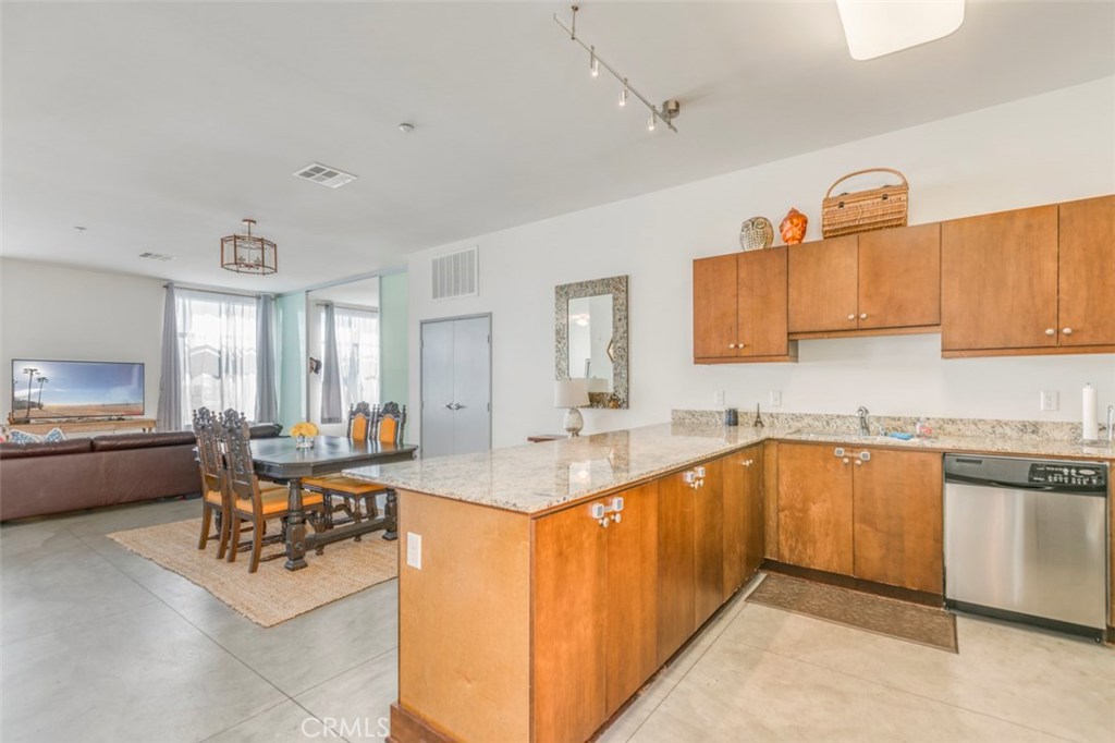Located in a cool industrialized complex in the historic downtown area of Anaheim, this stunning, open concept urban chic loft boasts a modernized design with east coast influences represented by soaring ceilings, concrete flooring and maximized use of space. Within ideal proximity to the Packing House which houses a variety of trendy walk-up restaurants, the property is also close to popular nightlife venues and just a few minutes from Disneyland, Angels Stadium, Honda Center and the Center Street Promenade. Highlights include the kitchen with granite countertops, stainless steel appliances and breakfast bar that opens directly to the dining area and Great Room big enough for media viewing, playing games and retreating simultaneously. Three bedrooms easily cordon off from main living areas with unique, floor to ceiling aqua opaque sliding doors. The residence also includes two full baths, an indoor laundry room, central air conditioning and a huge garage. The security gated complex includes a fitness room. This property is ideal for the executive, artist and entertainer given a welcoming atmosphere that is both accommodating and conducive to creative living.