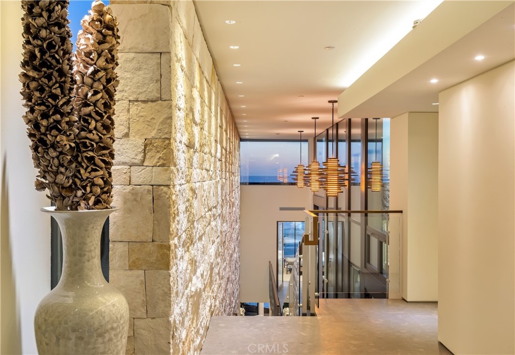 An architectural masterpiece, located on one of the most coveted stretches of coastline , an epic joining of land and sea 8 years in the making, the vision and design of renowned Laguna Beach Architect Mark Singer .The seamless, timeless and flawless design captures the iconic Laguna Beach views awaiting the most discerning clientele. The ultimate in modern coastal living awaits at this masterpiece directly on the sand, where sophistication, design and high-end finishes meet to capture mesmerizing white-water views and natural light throughout the homes floor to ceiling glass windows, high ceilings, decks and skylights. A private central courtyard with pool and spa opening up to the master and secondary rooms anchor the core of the homes design. the contemporary oceanfront residence exquisitely encapsulates unique designs , crisp angles and impressive fixtures with Texas limestone walls and Spanish limestone with fossil inlay floors throughout. Massive floor to ceiling glass doors open the main living area to an ocean side deck with direct private beach access and panoramic ocean, shoreline and sunset views. Enjoy breathtaking ocean breezes while entertaining family in the open living room with fireplace and sleek kitchen , well appointed island with bar, custom Poggenpohl cabinetry and high-end appliances. Appx. 4486 sf of living space, 2100 sf of outdoor decks and 800 sf of private beach the 4-bed, 4.5 bath design is served by an ocean-view elevator and two artistically designed floating staircases, custom lighting, floor-to-ceiling windows, a Savant smart-home automation system including Apple iPad/ touch technology. The resort like master suite is appointed with a large deck to the ocean , walk in closet, fireplace, free standing tub facing the pacific and disappearing glass on both sides of the room to take in the beauty of the coastline. A media room , office, 3-car garage, and 3 driveway spaces are additional highlights that complete this home.The ecologically sensitive home is LEED Gold Certified. Some of these details include a rainwater harvesting system which utilizes 50 percent of the roof, a Photovoltaic solar system, ENERGY STAR appliances and environmentally preferable and partially recycled products. Rest and relax watching the waves crash, walk to everything the famous Laguna village has to offer, restaurants, art galleries and shops are just a short stroll away. The Rare opportunity to own this trophy property awaits.