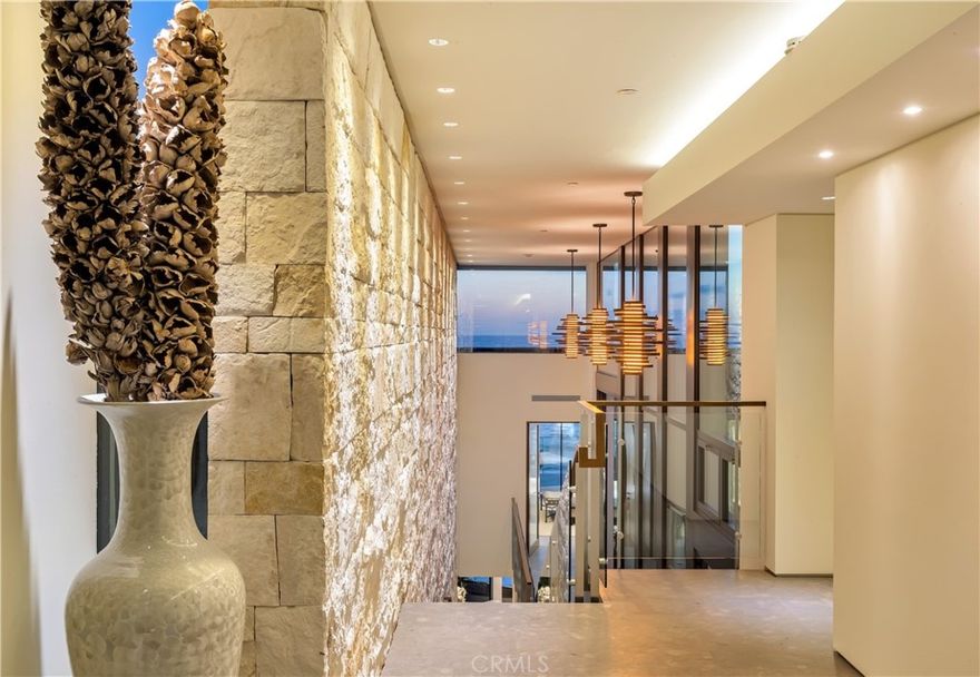 An architectural masterpiece, located on one of the most coveted stretches of coastline , an epic joining of land and sea 8 years in the making, the vision and design of renowned Laguna Beach Architect Mark Singer .The seamless, timeless and flawless design captures the iconic Laguna Beach views awaiting the most discerning clientele. The ultimate in modern coastal living awaits at this masterpiece directly on the sand, where sophistication, design and high-end finishes meet to capture mesmerizing white-water views and natural light throughout the homes floor to ceiling glass windows, high ceilings, decks  and skylights. A private central courtyard with pool and spa opening up to the master and secondary rooms anchor the core of the homes design. the contemporary oceanfront residence exquisitely encapsulates unique designs , crisp angles and impressive fixtures with Texas limestone walls and Spanish limestone with fossil inlay floors throughout. Massive floor to ceiling glass doors open the main living area to an ocean side deck with direct private beach access and panoramic ocean, shoreline and sunset views. Enjoy breathtaking ocean breezes while entertaining family in the open living room with fireplace and sleek kitchen , well appointed  island with bar, custom Poggenpohl cabinetry and high-end appliances. Appx. 4486 sf of living space, 2100 sf of outdoor decks and 800 sf of private beach the 4-bed, 4.5 bath design is served by an ocean-view elevator and two artistically designed  floating staircases, custom lighting, floor-to-ceiling windows, a Savant smart-home automation system including Apple iPad/ touch technology. The resort like master suite is appointed with a large deck to the ocean , walk in closet, fireplace, free standing tub facing the pacific and disappearing glass on both sides of the room to take in the beauty of the coastline. A media room , office, 3-car garage, and 3 driveway spaces are additional highlights that complete this home.The  ecologically sensitive home is LEED Gold Certified. Some of these details include a rainwater harvesting system which utilizes 50 percent of the roof, a Photovoltaic solar system, ENERGY STAR appliances and environmentally preferable and partially recycled products.  Rest and relax watching the waves crash, walk to everything the famous Laguna village has to offer, restaurants, art galleries and shops are just a short stroll away. The Rare opportunity to own this trophy property awaits.