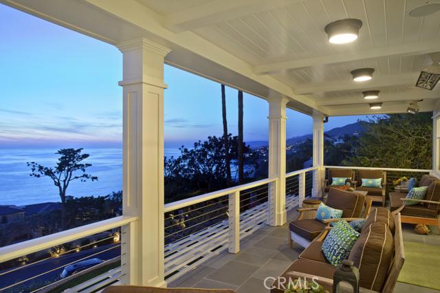 Gracing one of the largest parcels in Three Arch Bay, this exquisite Hamptons-style residence enjoys a perfect coastal orientation from its elevated vantage point on a double street-to-street lot. Sited in the most prestigious section of the guard-gated community, architect Bob White brilliantly integrated the panoramic ocean views into his design. Floor-to-ceiling windows & French doors frame stunning scenes of migrating whales, Catalina, whitewater beaches and the ever-changing tableau of ocean and sky. The home offers 5 en suite bedrooms and a thoughtful floor plan filled with natural light, ocean views and unparalleled quality. Exceptional materials include Walnut floors, tongue and groove vaulted ceilings, board-and-batten walls, fine built-in cabinetry, Calacatta marble, designer and vintage crystal light fixtures, Lutron lighting and whole-house audio. Outdoors, enjoy views from the Pennsylvania Bluestone verandas or relax in front of the fireplace in rear patio with barbecue and ocean view spa. The 15,682sf lot provides rare privacy, gated motor court, upper & lower garaging, estate-quality landscaping with specimen trees, and front lawn with fire ring lounge. Only steps to magical Three Arch Beach. The caliber is rare, the location matchless.