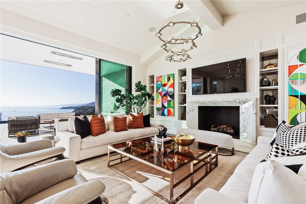 17 Coral Cove Way boasts one of the best views available in either Strand, offering breathtaking vistas of the Pacific, surf, coastline, city hills, and snow-capped mountains. This luxurious abode is California living at its best - the well-designed interior flow of this home easily provides a space for large groups or families to gather together, while allowing all five bedrooms to feel like private retreats, ideal for day-to-day living or luxurious entertaining. The stately great room and lounge with disappearing pocket doors leads to the backyard’s deck with fire pit, a patio with fireplace, and infinity pool with spa. The kitchen includes premium appliances, a walk-in pantry, butler’s kitchen, and a spacious island that can accommodate seating for six. Direct access to the patio is also enjoyed in the main-level primary suite complete with a fireplace, built-ins, beverage cooler, an enormous walk-in closet, and a walk-in shower and stand-alone tub. On the top floor you'll find 2 separate bedroom suites, and the subterranean floor provides a lounge and game room with bar and wine storage; an en-suite bedroom; and a gym with sauna, which could also be used as a theater. Located on one of the most desirable streets in the secluded South Strand, 17 Coral Cove Way offers easy access to both the beach and PCH with the Lantern District and Dana Point Harbor just a short distance away. This home has been meticulously and professionally maintained with continuous, weekly preventative maintenance to preserve the quality and look of the home. A true treasure along California's coveted coast- 17 Coral Cove Way is a prize property complete with the heart and soul of home.