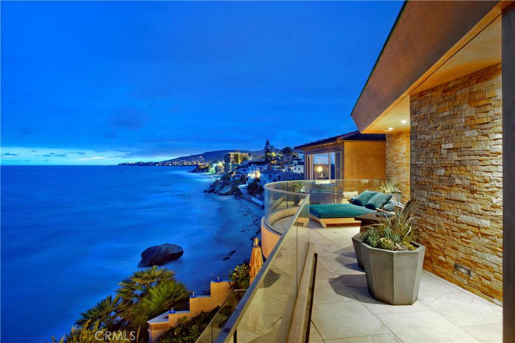 The backdrop for this ultimate coastal home is Laguna’s spectacular Wood’s Cove. Here warmth and sophistication are partnered beautifully with extraordinary materials and sleek contemporary lines. Dramatic ocean and sunset views are framed by floor-to-ceiling glass, while sublime interior spaces reflect the best in luxury living. The brilliant architecture and impeccable style merge interior hues and textures with the natural beauty of the sea, rocks and sand. The sizable 5,650 square foot plan unfolds over two levels and includes an open concept living room with professional-caliber kitchen and butler’s pantry, stylish formal dining room with sit down ocean views, large media room with wet bar, wine storage and advanced electronics. Four en suite bedrooms including Master Suite with office, private terrace, fireplace and spacious bath overlooking the crashing waves. Amenities in this sumptuous residence include controlled entry, Crestron whole-house system, exotic wood cabinetry, imported limestone floors, Weiland sliders, wood and glass interior doors, and electronic shades. The highly desirable location is an easy stroll by street or along sandy Main Beach to restaurants, galleries, shops and entertainment.