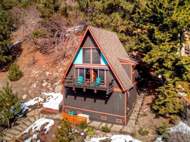 Perched high up on the mountainside with breathtaking panoramic views of the IE, DTLA & ocean. This A-frame sits on a double lot and has a driveway with a large area to turn around at the top. The main level of the home offers a bedroom, full bathroom and open plan kitchen/living area that opens onto a sunny deck where you'll find those fantastic views. Upstairs is an open loft bedroom with another balcony off the backside of the home, perfect for morning coffee amidst the trees. Underneath the home is a large buildup area where the washer/dryer are, and is super-spacious with lots of potential for expansion of the home's living area. Recent upgrades include custom wood flooring, a newer roof (replaced 2019), an automatic whole house generator, updated electrical panel (2020), and a storage shed with a 2020 snowblower. This home will transport you to a bygone era and you will feel like James Bond in your secret Mountain Hideaway.