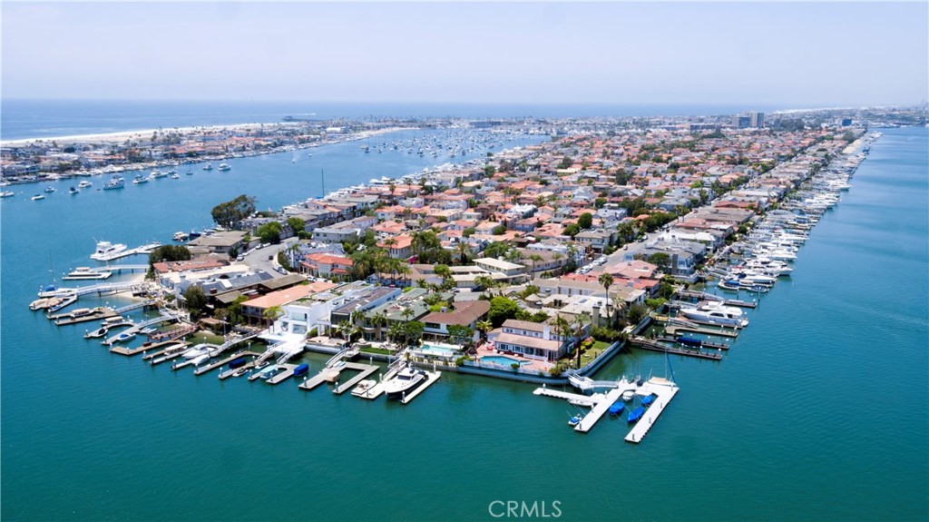 Beyond an intricately detailed wrought-iron gate, at the end of an inviting private drive with motorcourt and fountain, this exceptional custom estate presents the most coveted homesite on all of Newport Beach’s exclusive Lido Isle. With 200' of bay frontage, an unparalleled corner location, multiple docks for large yachts, and incomparable panoramic views of Newport Bay and city lights, the Cape Cod-inspired residence elevates Southern California living to impressive new heights. A nautical New England ambiance embellishes at every turn, with classic shingle-style architecture, expansive lawns, extensive use of brick, and a white picket fence lending added appeal. Approx. 4,388 s.f., the 2-story estate was originally crafted in 1942 and now hosts 5 bedrooms, including 2 on the main floor, 5 baths, a large family room, a bright and open kitchen, wood floors, and classic white-painted molding and paneling. Enchanting bay views fill most rooms, including a master suite with deck and 2 walk-in closets. Entertain graciously on waterside patios that host a pool and spa, or take advantage of Lido Isle’s private tennis courts, beaches and playgrounds.