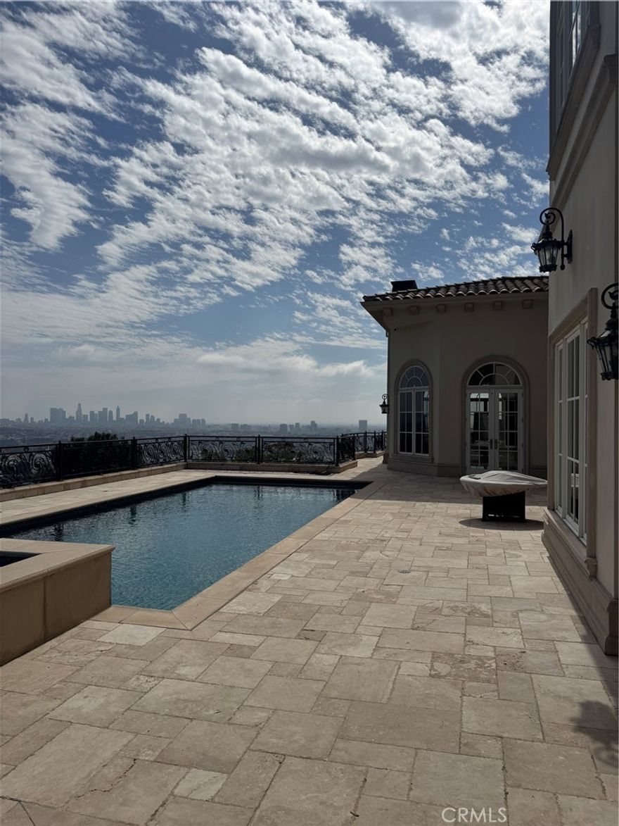 Nestled in the highly coveted Oaks in Hollywood Hills is a custom built Mediterranean Villa with unobstructed views in nearly all directions. Built in 2004 and sitting on two parcels spanning .32 acres; this estate consists of 5 en suite bedrooms and 7 bathrooms  within its 7,168SF of living space. Gated entry and a long drive way offers privacy and ample parking for guests. Double doors with marble flooring and high ceilings welcome all guests to the open living room filled with an abundance of natural light through each window. Views of Griffith Observatory, downtown LA, Pacific Palisades, and Long Beach can be seen from different vantage points. A chefs kitchen with high end built in appliances and large island is perfect for large gatherings. The main level also includes a formal dining room, family room, en suite bedroom, and powder room. The upper level consists of 4 en suite bedrooms and a loft. Highlighting the upper level is the master suite and its extra large walk in closet, bathroom, and balcony. On the exterior, this home includes a custom pool, outdoor cooking area, bathroom, and plenty of lounging space to enjoy the unobstructed views of Southern California.