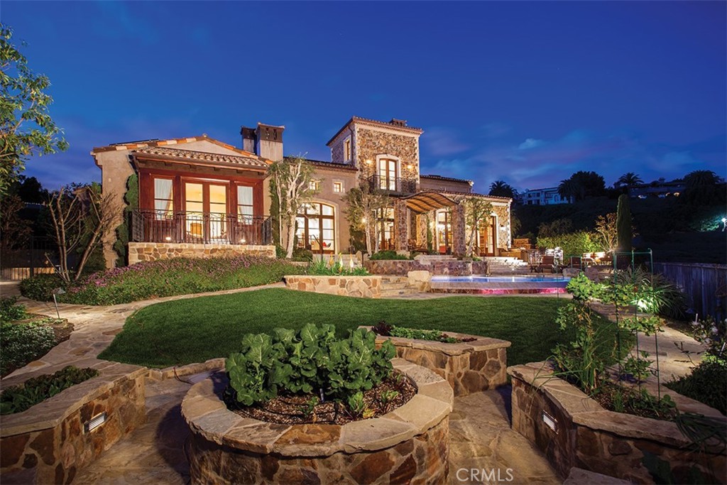Escape to luxury living with this breathtaking custom estate in the prestigious Pelican Hill community of Newport Coast. With sweeping views of the emerald fairways and greens of the Pelican Hill Resort and endless vistas of the Pacific Ocean, this property offers the ultimate southern California coastal resort lifestyle. With just over 8,995 sq. ft. of living space on a sprawling 20,000 sq. ft. lot, this 7-bedroom, 8.5-bathroom home boasts timeless design and the finest craftsmanship. Inspired by Tuscan countryside villas, the Mediterranean-style exterior gives way to a muted interior palette rich in detail.
Take in the breathtaking views from the large, inviting common living spaces, which open onto an enclosed courtyard and a lush backyard complete with a pool, spa, loggia, BBQ pavilion, bar, outdoor fireplace, lounge area, and raised seasonal vegetable garden. The property's rare ground-floor master retreat offers a stone-clad bathroom with dual walk-in closets and direct access to the backyard. Other amenities of this exceptional property include a spa equipped with a sauna, steam room, and hammam table, indoor pool, gym, theater, service quarters, laundry, and subterranean garage. Conveniently located just 15 minutes from world-class shopping and dining, John Wayne airport, award-winning golf courses, major freeways, performing arts centers, and Newport Harbor, this home truly must be experienced to fully appreciate its beauty and value. Don't miss this once-in-a-lifetime opportunity to own a piece of paradise.