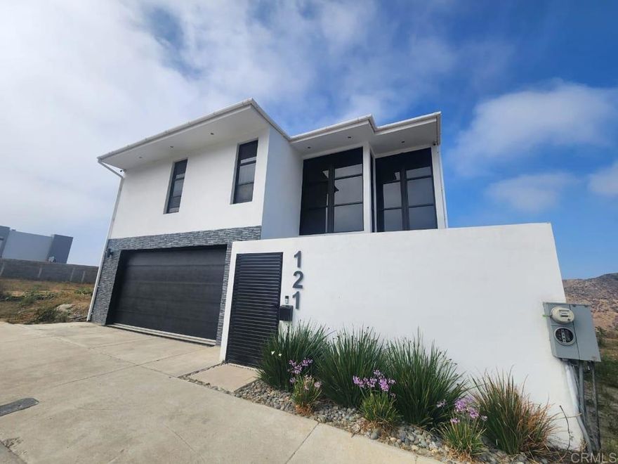 Splendid house for sale, located in the newest gated community in the city. With first class construction, subway services, security booth with 24/7 guard and excellent location north of the city with immediate connectivity to the Ensenada-Tijuana Scenic Highway via San Diego.  This beautiful residence was recently built. High quality materials were used that combined with good taste and functionality in its spaces generate a pleasant and harmonious environment.  The first level consists of a spacious master bedroom with walk-in closet and full bathroom. Next two bedrooms which share a full bathroom. Laundry room and a spacious electric garage for two cars. On the second level are the common areas designed in open concept. It consists of a large living room with fireplace, dining room, both facing a spectacular terrace with retractable windows and an incredible ocean view. Large kitchen with island and beautiful quartz countertops. Pantry room and half bath. Second master bedroom with walk-in closet, full bathroom with double sinks and whirlpool tub.  Close to restaurants, hotels, hospitals, schools of all levels, gyms, gas stations, cafes and various stores. Just 10 minutes from downtown Ensenada, 25 minutes from Valle De Guadalupe, 1 hour from Tijuana, 1 hour 15 minutes from the US border.  Come and be amazed by this beautiful home!  EQUIPMENT AND MATERIALS: Alarm with video cameras Cistern 5,000 liters with hydraulic pump Gas fireplace One air conditioning unit in living room Jetted whirlpool bath tub Custom cabinets with quartz in kitchen and bathrooms Electric curtains Automatic dishwasher Garbage disposal in sink Double glazed windows  Exterior construction based on HEBEL blocks (This innovative material is fire resistant, thermal insulator, acoustic insulator, moisture resistant and provides greater structural strength). This material is sustainable and ecological.