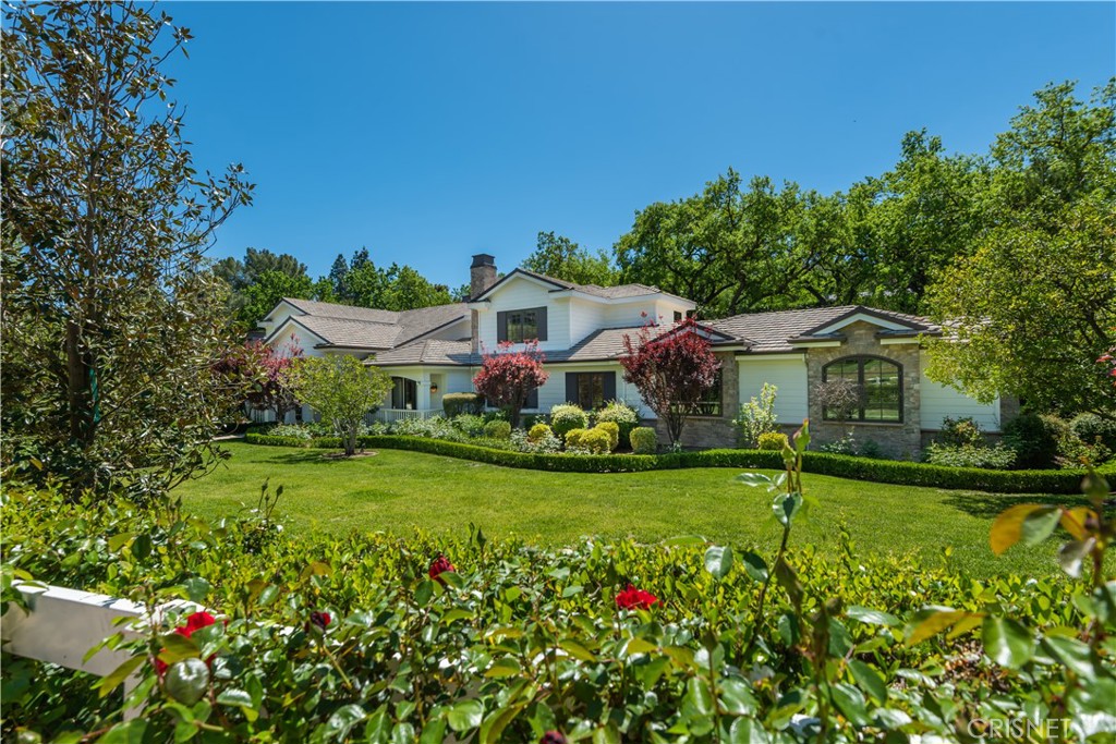 This beautiful Craftsman style estate is model sharp and is sited on stunning grounds that include a two room guest house. Highlights include a superb, chef's center island kitchen with Viking refrigerator and commercial range with copper hood, sunny breakfast room, adjoining large family/game rooms, formal dining room with butler's pantry, restaurant style pub with mahogany bar and wine storage, adjoining lounge with fireplace, custom office with fireplace & open beam ceiling, and a stunning home theater. There are five ensuite bedrooms in the main house including the primary suite with Calcutta stone bath, steam shower, and large balcony overlooking the very private grounds. There is also a five car garage with lifts for storage plus additional courtyard parking. The immaculate and lushly landscaped grounds include a sparkling pool, spa, basketball area, covered patio with full barbecue center, firepit, warp around loggias with fireplace and waterfall, all set amongst mature trees and lush privacy landscaping. The guest house includes a living room and bedroom, with adjoining covered patio. Additional home features include a two story entry, wood floors, and Lutron lighting system. With a convenient, center of Hidden Hills location, and just steps from the community pool and tennis courts, this home has much to offer.