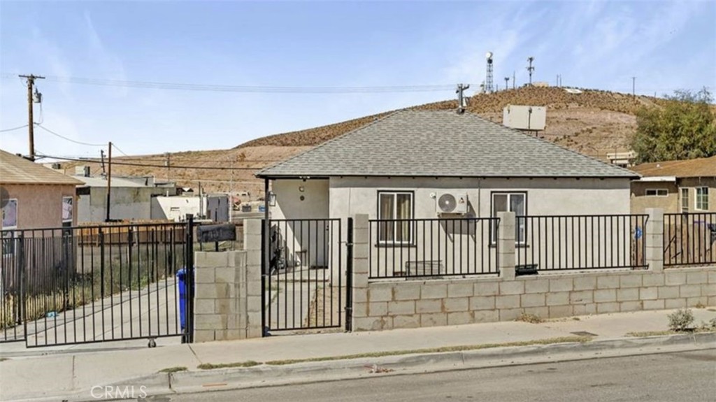 Welcome to this  2-bedroom, 1-bathroom home, offering 727 sqft of comfortable living space. This property features a new iron and brick fence, fully enclosing the yard for enhanced privacy and security. Stay comfortable year-round with Central Evaporative Cooling. Inside, you’ll find a bright and open floor plan with laminate flooring throughout, creating a seamless flow from room to room. The modern kitchen boasts appliances, sleek white and gray quartz countertops, and a spacious layout with plenty of cabinet space. Large windows flood the home with natural sunlight, enhancing the warm and inviting atmosphere. The stylish bathroom features a tiled bathtub and continues the home’s consistent design with laminate flooring. Additionally, the laundry area is conveniently located in the kitchen. Step outside to the spacious 7,800 sqft lot, offering ample room for RV parking, off-road toys, or space to create your own outdoor oasis—perfect for outdoor enthusiasts or those needing extra space for hobbies. The property features front and back door access with a private driveway and gated parking. Conveniently located near schools, shopping, and restaurants, this home offers both comfort and accessibility.