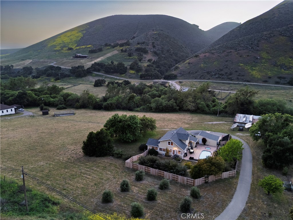 Welcome to 4651 Tepusquet Road—a timeless, storybook farmhouse set on a beautifully maintained ranch in the heart of the Santa Maria Valley. Originally constructed in 1914 and thoughtfully relocated to this peaceful setting over four decades ago, this inviting three-bedroom, two-and-a-half-bath home offers approximately 2,800 square feet of updated living space, blending warmth, character, and functionality.
The home’s charm begins at the front entry, where a bright and cozy mudroom/sunroom invites you to enjoy morning coffee, a good book, or sunshine year-round. Inside, hardwood floors run throughout the main level, while large windows flood the home with natural light and showcase serene views of the surrounding acreage.
The refreshed kitchen offers ample space for cooking and gathering, with adjacent dining and family rooms that are ideal for entertaining or relaxing with loved ones. A wood-burning fireplace warms the den, and a dedicated office off the family room provides the perfect space for remote work, creative pursuits, or a quiet retreat.
Upstairs, the spacious primary suite has vaulted ceilings, generous closets, and an en suite bathroom. Two additional bedrooms share a full bath and offer comfort and style for family or guests.
Step outside onto the expansive deck—perfect for starlit dinners, morning sunrises, or quiet reflection overlooking the rolling grounds. Just beyond, a solar-heated swimming pool and hot tub offer a luxurious escape, powered by the property’s owned solar system.
The large barn adds value and versatility, with room for agricultural storage, equipment, or a workshop/studio. The surrounding landscape is thoughtfully designed with drought-tolerant plants and raised garden beds for vegetables, flowers, or herbs. A variety of fruit trees—plum, lemon, orange, tangerine, lime, olive—and blackberry vines provide a true farm-to-table experience.
The flat, usable land is ideal for horses, a boutique vineyard, organic farming, or even adding a second home or ADU. A year-round creek adds natural beauty and additional potential for farming or grazing on the acreage beyond.
Located just off Foxen Canyon Wine Trail and within 2 miles of amazing wineries, this property offers the perfect balance of rural tranquility and modern convenience. Whether you're seeking a peaceful retreat, an entertainer's dream, or a working ranch, this exceptional property offers endless opportunities.