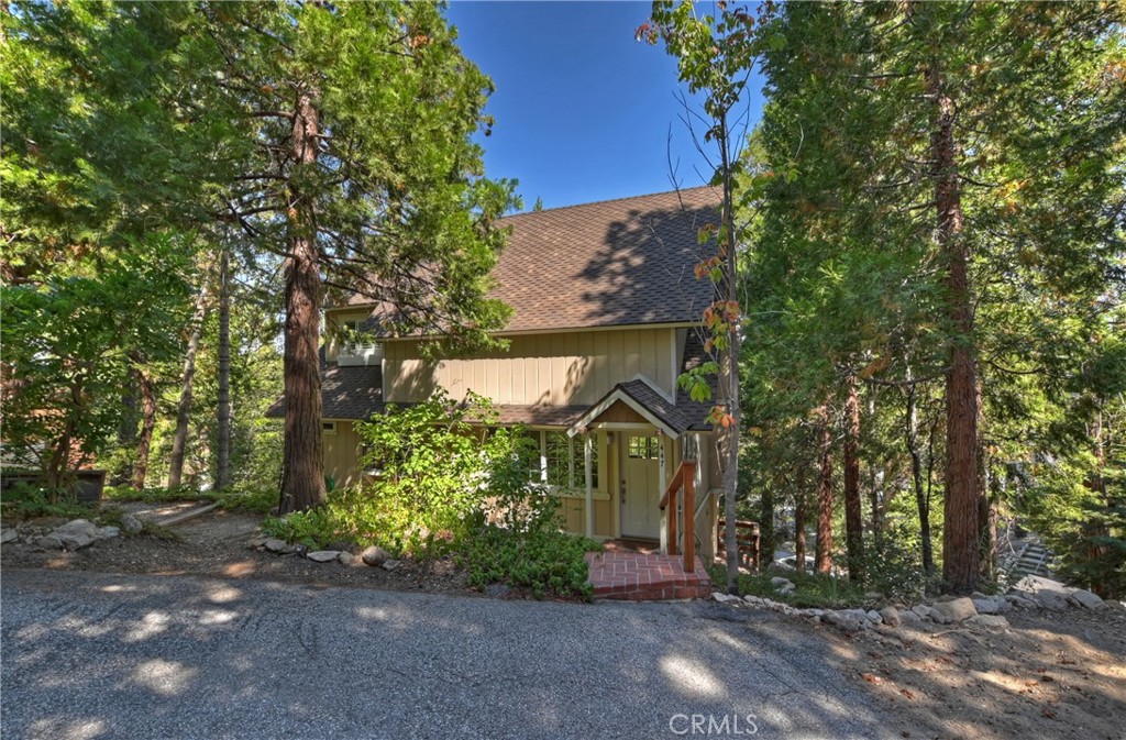 Cozy, cute, comfortable & affordable! This sweet little bavarian has been lovingly cared for & is ready for a new owner. Nestled in the trees with beautiful forest surroundings sits this updated getaway. Many upgrades have been done including a kitchen remodel with custom wood cabinetry, granite countertops, stainless appliances & brick flooring. There is one bedroom (was being used as a den/office) on the main level along with a full bath. Nice sized living area with beamed ceilings, a rock fireplace, lots of windows & sliding glass doors leading out to the spacious deck. Upstairs are two spacious, light & bright bedrooms with vaulted ceilings. One of the bedrooms has a small loft area which could be used for extra storage or sleeping space. There is also another full bath upstairs. Down the stairs from the deck, you will find the single car garage & driveway for direct access from Grass Valley Road. There are also 2 additional flat parking spaces next to the driveway so room for everyone! Your primary access is from the access road above with just a few steps down to the front door. So no matter the season, you will be able to get in! Charming yard area above the home offers a nice flat patio area (formerly had a greenhouse) that is perfect for BBQ's, or even a great spot for a hot tub! Lots of mature ground cover & foliage make for a lush forest feel & help with erosion. There is a good size storage area under the home & even a whole house generator so the lights are always on! This cutie is in great shape and move in ready!