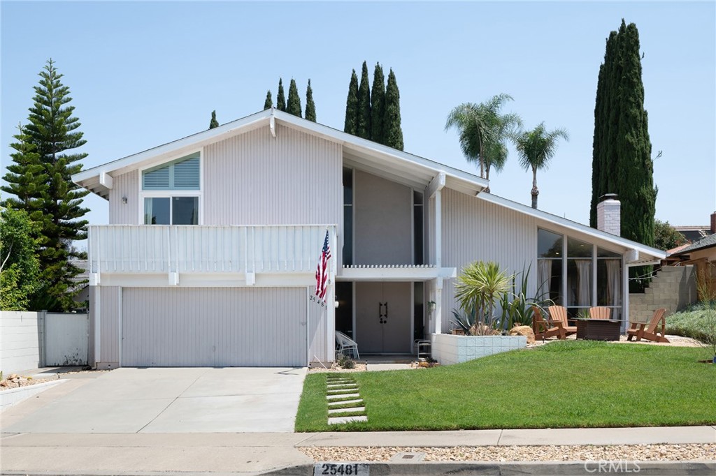 Experience the best of Mission Viejo living at 25481 Classic Drive, where classic mid-century style blends seamlessly with modern, thoughtful upgrades. The spacious 4-bedroom, 3-bathroom home sits on an oversized 8,733 sqft lot in the heart of the city. From the moment you arrive, the charming curb appeal welcomes you with a lush grassy front yard and a cozy fire pit, perfect for relaxing with friends and neighbors.
Plug your car into the EV charger before entering the home’s sun-filled grand foyer with soaring ceilings. The formal living room, anchored by a stunning stone fireplace, flows into the open dining room for easy entertaining. The kitchen offers stainless steel appliances, a newer dishwasher, and a functional layout that opens to a second living space with another breathtaking stone fireplace. The first floor features a versatile bedroom or home office with custom walnut shelves, a newly remodeled full bathroom, laundry room, and direct access to the oversized 2-car garage. Upstairs, the spacious primary suite boasts two closets and a remodeled bathroom that’s truly a masterpiece. The exquisite walk-in shower features beautiful tile and Brizo hand and rainfall showerheads. Finishing touches include dual sinks and a dedicated makeup vanity. Two additional bedrooms and another full bath complete the upper level.
The expansive, private backyard is perfect for both relaxation and play, with ample space to enjoy now or add a sparkling pool if desired. Recent upgrades include HVAC system, ceiling fans, EV charger (J1772), recessed lighting and light fixtures, durable vinyl plank flooring, Bluetooth-controlled irrigation, double-pane bedroom and bathroom windows, and fresh landscaping with a mix of drought-tolerant plants, mature citrus and cypress trees.
With no Mello-Roos, no HOA, a convenient location near parks, shopping, dining, top-rated schools in the Saddleback Valley School District, scenic trails like the 15-mile Aliso Creek Bikeway and optional Lake Mission Viejo access, this home delivers comfort, style and true California charm.
