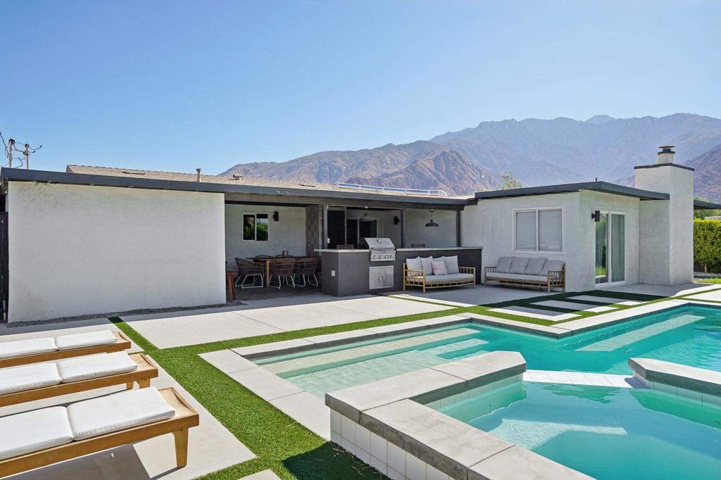 TURN-KEY and fully remodeled, this vibrant mid-century masterpiece is move-in ready and packed with style, views, and endless possibilities! The moment you step inside this 4 bedroom, 3 bathroom, nearly 1,900 SF home, modern design and sleek finishes welcome you at every corner. The open living room flows effortlessly into a chef's dream kitchen, complete with Italian-imported cabinets, black stainless steel appliances, quartz countertops, counter to ceiling white penny round tile backsplash, floating shelves, and a floor-to-ceiling pantry- perfect for cooking, entertaining, and showing off in style! Step outside and prepare to be amazed--this backyard is the ultimate desert playground! A covered patio with a 16-foot bar, built-in grill, and mini fridge makes entertaining a breeze, while the brand-new landscaping and hardscape frames a sparkling pool with raised spa and modern tanning shelf. And just wait until you see the jaw-dropping San Jacinto Mountain views! There's even a separate seating area with a gas fire pit, making this the ultimate hangout spot day or night. Back inside, the primary suite is cozy with a spacious seating area, show stopping fireplace and tons of natural light making this the perfect private retreat. The spa-inspired bathroom featuring a dual vanity, fully titled walk-in shower, and an oversized walk-in closet (a rare find in mid-century homes!). Plus, with direct access to the backyard, your morning coffee or evening unwind has never looked better. The 3 other guest bedrooms are just as nice and inviting for all of your family and friends. The game room is truly an added bonus to this home with 2 arcade consoles, foosball table, air hockey, and space to watch all of the big sporting events! And here's the kicker--this property isn't just gorgeous, it's a money-maker too. With peak season rental rates around $450 per night, it's the perfect high-performing short-term rental, vacation getaway, or forever home. This Palm Springs stunner has it ALL--style, views, and income potential. Don't wait... your dream lifestyle starts here!