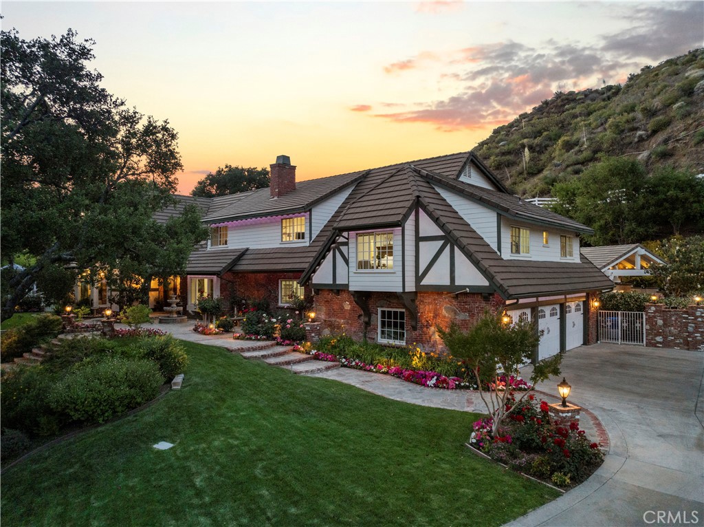 Welcome to 25730 Sand Canyon Rd, a stunning private, custom estate nestled in Santa Clarita's prestigious Sand Canyon. This luxurious 5-bedroom, 4-bathroom residence offers the rare combination of refined living and total seclusion. Private gated entry leads to sprawling grounds adorned with 7 heritage oak trees, 10 planted oak trees, multiple citrus, apple, and peach trees, a boutique vineyard, PLUS a custom climate-controlled wine tasting room—perfect for intimate gatherings and entertaining in style. The expansive property includes an RV garage with over 40’ of space and full hookups, a 3-car garage, generous guest parking plus 50 amp service to the RV garage and shop. Inside, the home is full of warmth and character: vaulted wood-beamed ceilings, refinished oak floors, beautiful custom fireplaces, custom lighting, plenty of natural light PLUS a new whole house water filtration system to ensure clean water throughout the home. The formal dining room has a built-in china hutch—perfect for dinner parties or holidays. You'll fall in love with the fully remodeled chef’s kitchen, featuring a Sub-Zero refrigerator, Wolf range, farmhouse sink, marble countertops, and a generous center island—all surrounded by pristine white cabinetry and a cozy breakfast nook. The primary suite is a TRUE retreat, complete with a fireplace, built-in cabinetry, private balcony, plus a luxurious ensuite with steam shower, freestanding soaking tub, and dual vanities. Additional highlights include a downstairs bedroom and bath, an expansive family room that opens to a game room and full bar with dual wine fridges and ice maker. Step outside to your own resort-style backyard, meticulously designed with lush professional landscaping, serene fountains, a fully remodeled pool and oversized spa, an outdoor kitchen with BBQ, a fireplace, gazebo, and panoramic sunset views. This is more than a home—it’s a sanctuary for those who value beauty, privacy, and distinction. Schedule your private showing today and experience the unparalleled lifestyle that Sand Canyon has to offer! NO HOA or MELLOROOS!