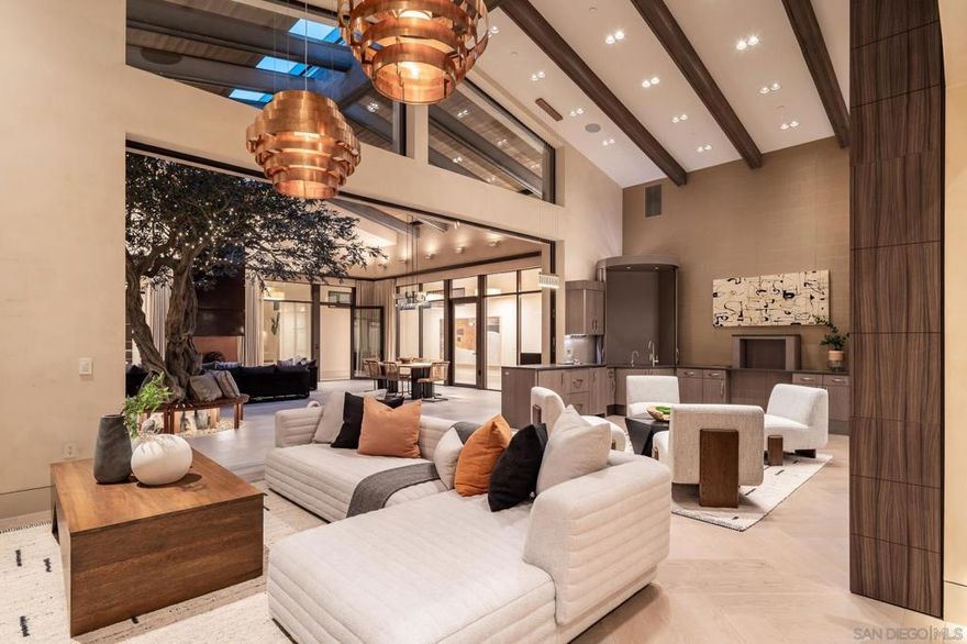 Designed by renowned local architect Trip Bennett, this gated one-acre La Jolla estate masterfully blends harmonious architecture with cutting-edge sustainability. Enter through a striking courtyard featuring a fully retractable roof that brings the outdoors in. This home is LEED Gold Certified and equipped for off-grid living, showcasing more than 8,000 square feet of intentional home design, single-level layout, fully ADA accessible, private guest suite with separate entrance, top-tier appliances, smart home technology, Italian Lapitec natural stone countertops, fire-hardened exterior, locally sourced materials, a four-car garage, temperature-controlled wine storage for nearly 700 bottles, and an expansive flat lawn. For complete energy resilience, the home includes a dual-fuel generator, a 1,000-gallon propane tank, solar hot water supported by geothermal heating, and an array of 80 owned solar panels. A reverse osmosis water filtration system and independently climate-controlled zones ensure personalized comfort and efficiency throughout. This is sustainable luxury at its finest.