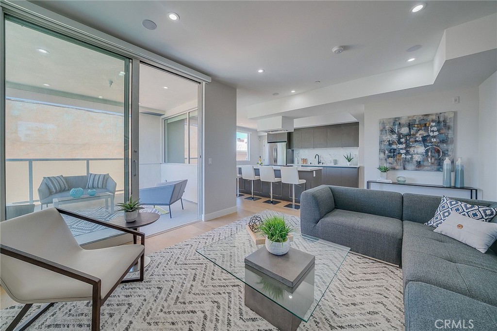 Epitomizing ultramodern luxury, this captivating condominium in West Hollywood is a visionary masterpiece with unforgettable views reaching the Hollywood Sign. Spanning the entire 1350 sqft top level of a high-performance building, this newly constructed condominium with smart technology showcases a distinctive style and palette that highlights its aesthetic beauty. Flooded with natural light from expansive glass, elevated living spaces are
framed by floor-to-ceiling windows and retractable doors, offering an effortless indoor-outdoor lifestyle. A stunning top-of-the-line kitchen with quartz and stainless accents opens to an elegant dining and living area, creating a fashionable venue for entertaining. Inspired by the ethos of five-star resorts, dual primary suites expand to include tailored closets and lavish baths. Finished with muted European oak floors, private balcony, and secured parking. Moments from L.A.’s legendary entertainment, this picturesque environment celebrates a high walk score of 93. Surrounded by the Sycamore District and blocks from the epicenter of iconic landmarks, the locale embodies the essence of Hollywood.