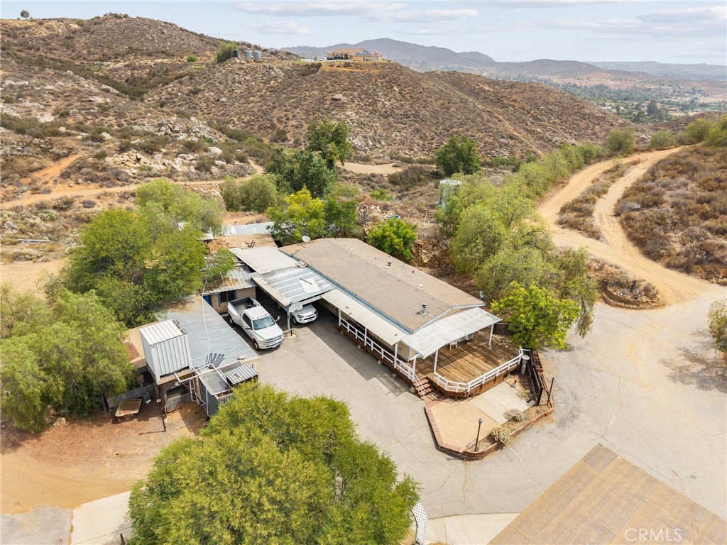 If you're searching for a private compound featuring an existing home and multiple amenities, this property is a must-see! It offers a scenic pad with incredible views to build your dream home, an additional pad perfect for an ADU, and a dedicated RV parking area with full hookups for family and friends. Plus, there's extra covered RV parking, a spacious recreation area for family fun, and a versatile workshop for your projects. Don't forget about the functioning water well with a brand new motor is on property with a 7,500g storage tank. Words, videos, or images can't do this property justice—it's truly something you need to experience in person. Custom house plans for main pad available at no cost!!! Contact me today to schedule your private tour!