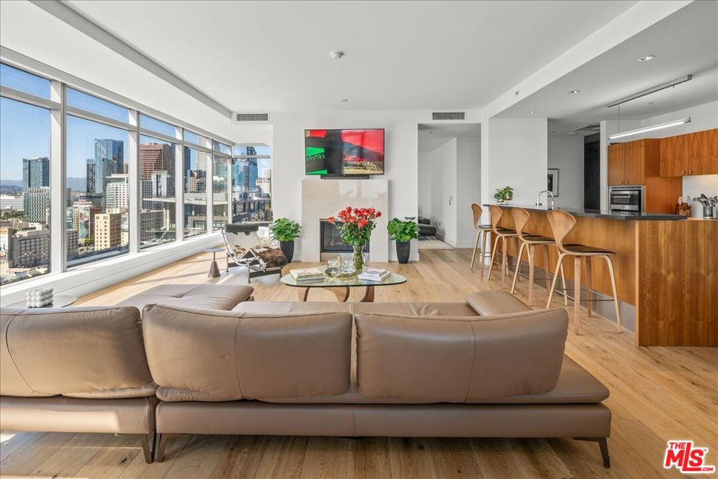 Welcome to Penthouse 102, a rare, light-filled residence perched on the 22nd floor of the EVO building in the heart of DTLA's South Park District. Just steps from LA Live, Crypto.com Arena, and some of the city's best restaurants, this nearly 2,400 sq ft corner penthouse offers soaring ceilings and the ultimate open-concept floor plan designed for elevated urban living. Inside, you'll find brand-new wide-plank European oak floors, floor-to-ceiling windows, and a seamless flow between the kitchen, living, and dining areas all framed by sweeping skyline views. The chef's kitchen features Viking appliances and a welcoming fireplace anchors the main living space. The spacious primary suite includes an oversized marble bathroom that exudes spa-like luxury, while the private guest suite offers its own marble-clad bath. An exposed concrete accent wall leads to a media room with built-in surround sound, and a private balcony with a grill makes this penthouse the ultimate DTLA entertainer's dream. Ground-level parking adds ease to this rare and stylish city retreat. Set on one of Downtown LA's most desirable blocks, the vibrant South Park neighborhood puts you steps from Pine & Crane, OrangeTheory, South Park Pharmacy, Starbucks, and more. You're just minutes from Crypto.com Arena, LA Live, the Ritz-Carlton, and the Pico Metro Station. With a Walk Score of 95 and Transit Score of 100, car-free living is easy. As LA prepares to host the 2028 Olympics, billions are being invested in downtown development. This is your opportunity to own a piece of LA's future.