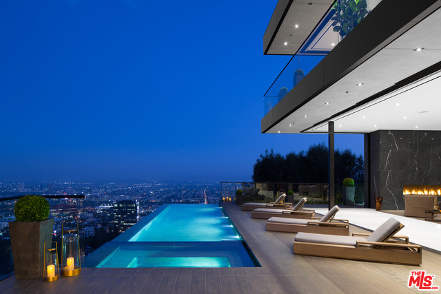 One-Of-A-Kind Masterpiece Nestled In The Notorious Los Angeles Bird Streets! Renowned architect Paul McClean has outdone himself with show-stopping, *fully furnished* estate! Breathtaking panoramic views spanning from Los Angeles to Catalina Island. French cobblestone driveway leads to custom rotating carport. Bedrooms feature city views. Lounge is entertainer's paradise with wine cellar, swing suspended from ceiling, city views & balcony with wraparound fire pit. Custom-made Italian kitchen by ErnestoModa with Fendi chandelier and Miele appliances. Ethereal floating stairway is accented by handcrafted 34' Murano chandelier with 24k gold leaf & handblown glass. Marble bathrooms and 4 ultra chic Montigo fireplaces highlight the elegance. Fully equipped gym features horizontal massage shower. Master Suite is pièce de résistance with full bar, showroom closet and opulent bath. Home also has in-home movie theater, infinity pool & Creston Smart System.