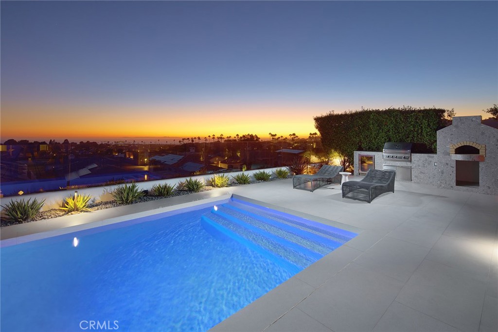 Perfectly positioned within the coveted Estates at Monarch Beach, this California coastal modern estate is a masterful blend of contemporary design, refined comfort, and effortless seaside living. Walls of glass frame panoramic views of the Pacific Ocean, Catalina Island, and the lush Monarch Beach Golf Links, filling the home with natural light and the soothing rhythm of ocean breezes. Entertain with ease in the expansive outdoor spaces, complete with a saltwater pool, oversized spa, and both covered and open-air lounging areas with outdoor kitchen, all surrounded by drought-resistant landscaping. Inside, the massive view great room melds with the dining area and freshly updated kitchen which features a new cooktop and premium Meile and Subzero appliances, seamlessly extending to an outdoor chef’s kitchen with barbecue, wood-burning pizza oven, and refrigeration. Upstairs, the primary suite offers a private sanctuary with a spa-inspired bath, large patio, and a sitting room with fireplace. All five bathrooms throughout the home showcase designer fixtures and floating cabinetry, while two generous ensuite bedrooms on the main level create a welcoming retreat for guests. Every detail has been thoughtfully curated, from the Control4 and Josh Ai smart home integration (connection required) to a whole-house water filtration and softener system. Additional features include central air, tankless water heaters, security cameras, an oversized three-car garage, a power generator, exterior remote-controlled window coverings, and Sonos speakers throughout. With 24-hour guard-gated security and proximity to world-class dining, shopping, and resorts, this home presents a rare opportunity to embrace the very best of Monarch Beach coastal living.