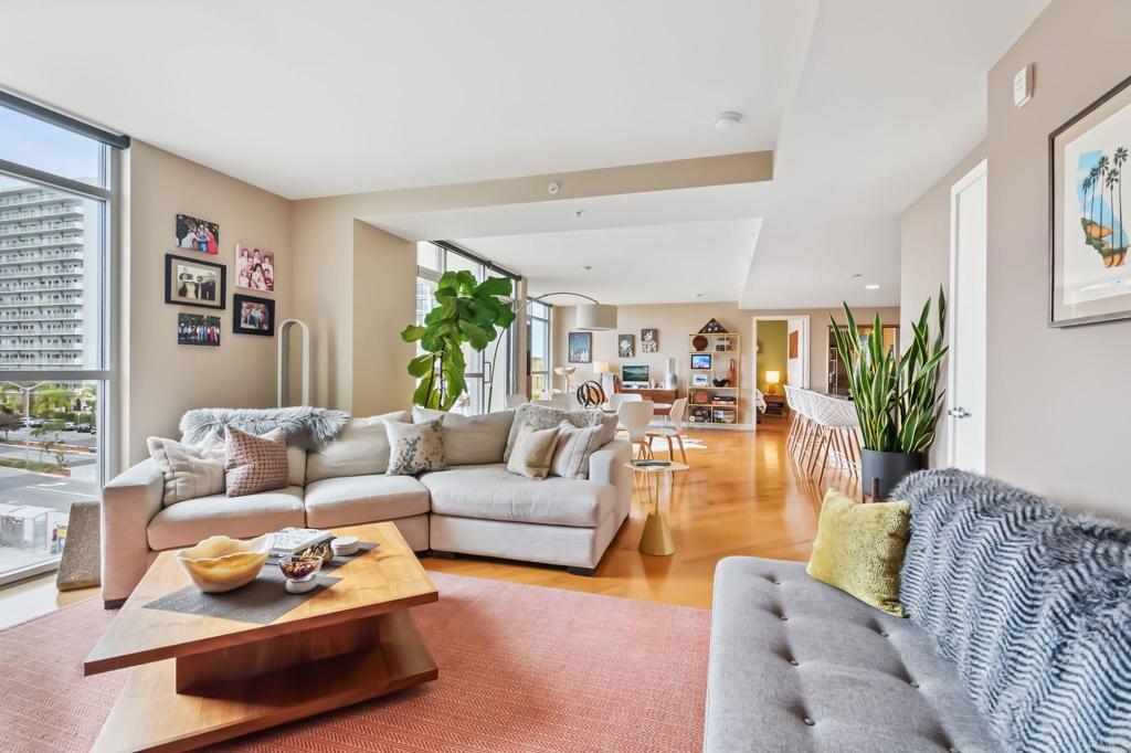 Stylish and sun-drenched, this 5th-floor residence at the iconic Egyptian showcases architectural flair and thoughtful design. Floor-to-ceiling north-facing windows, gleaming hardwood floors, and two private balconies complement the open, flexible layout. Currently lives as a spacious 1-bedroom but easily converts to a 2-bedroom setup with a second primary suite—while maintaining an inviting flow. You’ll find a proper entry with half bath, a full laundry room off the kitchen, and two tandem parking spots with a brand new EV charger. The primary bedroom features a walk-in closet and dual vanity bath. HOA covers water and gas. All this just half a block to the Sunday Farmers Market, Trader Joe’s, 24-hour Ralphs, and some of Hillcrest’s best dining, bars, and boutiques. Balboa Park and the Zoo are just a short stroll away.