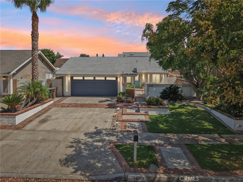 Welcome to 242 N Camino Arroyo, a stunningly updated home in Anaheim that blends modern design with comfortable living. This 4-bedroom, 2-bath residence is thoughtfully designed with an open-concept floor plan, abundant natural light, and stylish finishes throughout. Inside, you’ll find a spacious living area anchored by a cozy fireplace and illuminated by skylights that brighten both the kitchen and living room. The beautifully remodeled kitchen features sleek white cabinetry, high-end stainless-steel appliances, and plenty of counter space to inspire your inner chef. The dining area flows seamlessly into the main living spaces, creating a warm and inviting atmosphere. The private master suite is a true retreat, offering a massive walk-in closet and a spa-like bathroom with dual sinks and modern finishes. Upstairs, a versatile loft area leads to the fourth bedroom and its own closet, along with a balcony that captures a pleasant view—ideal for morning coffee or evening relaxation. Behind a closet wall, you’ll also discover a capped and closed-off additional bathroom, ready to be completed and transformed into extra functionality. The upgrades continue with a fully insulated garage featuring epoxy floors, making it as practical as it is polished. Electrical updates throughout the home provide modern efficiency and peace of mind. Additional highlights include updated flooring, recessed lighting, and a functional layout that balances modern upgrades with everyday comfort. Outdoors, the home offers a large front yard, spacious driveway, and attached garage, while the backyard provides a peaceful retreat with grassy and paved areas—perfect for gatherings, play, or simply unwinding in the fresh air. With its prime location in Anaheim, close to parks, schools, shopping, and dining, this home offers the perfect blend of style, space, and convenience. Don’t miss the chance to make this turnkey property your new home!