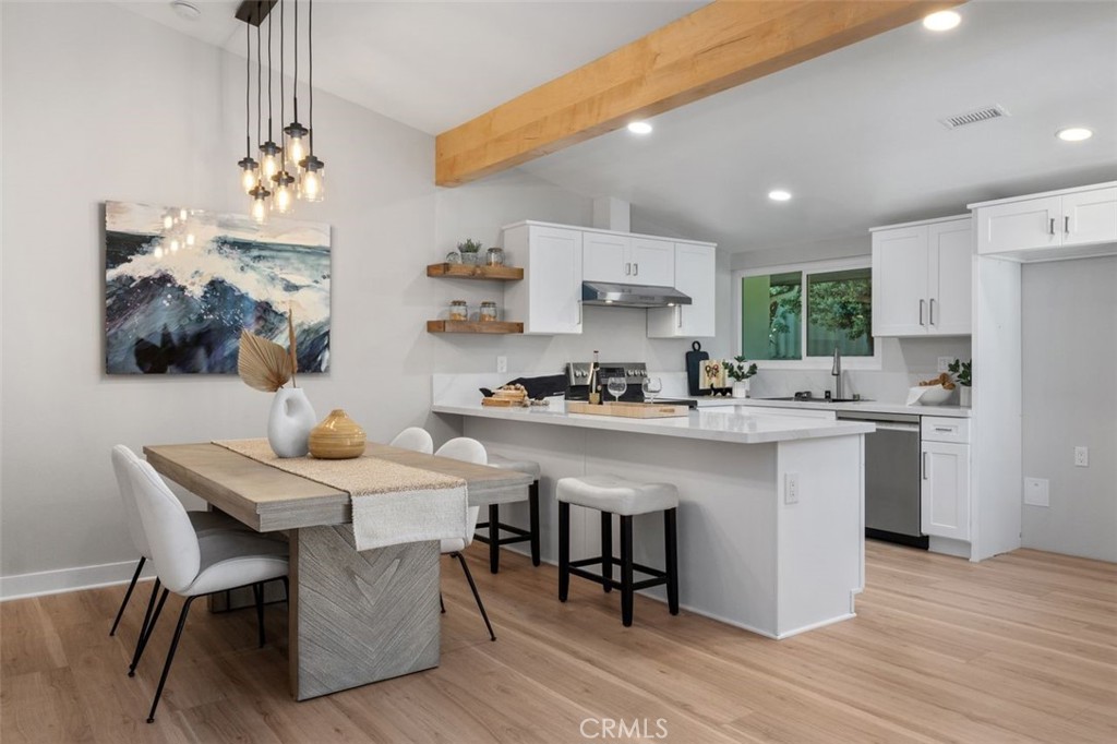Step into 4305 Hilaria Way, a Newport Beach home where mid-century modern architecture and contemporary updates come together in perfect balance. Originally designed in the 1960s by acclaimed Palm Springs architects William Palmer and Dan Krisel, this Park Lido townhome has been thoughtfully reimagined for today while honoring its architectural roots. A short set of steps leads you into the hallmark of mid-century living: an open floor plan that blends kitchen, dining, and living spaces with access to the outdoors. Wide wood laminate flooring, vaulted ceilings, recessed lighting, and a timeless exposed wood beam create a bright, inviting space. The remodeled kitchen adds a contemporary touch with quartz countertops, stainless steel appliances, shaker-style cabinets, and a long breakfast bar that anchors the heart of the home. Just off the kitchen, the dining room features striking pendant lighting, while the spacious living room centers around a classic fireplace beneath vaulted ceilings. Upstairs, the primary suite showcases plantation shutters and a remodeled bathroom with a custom dual vanity, shaker cabinetry, wall-mounted faucets, and a tiled walk-in shower with sparkling new glass enclosure. Two secondary bedrooms, also with shutters, share an updated bathroom designed with the same attention to detail. Outdoors, the private patio with Saltillo tile and a lush green backdrop reflects the indoor-outdoor lifestyle that has defined California living for decades. A spacious two-car garage, an HVAC installed and repiped with PEX in 2022, and an oversized laundry room with abundant storage add practicality to the design. Park Lido offers residents four community pools and plenty of green spaces, all just half a mile from the sand. You're walking distance to restaurants and shops, and minutes from the 405 and 55 freeways. Schedule your showing today for 4305 Hilaria, and take this opportunity to own a piece of Newport Beach history update for today's living.