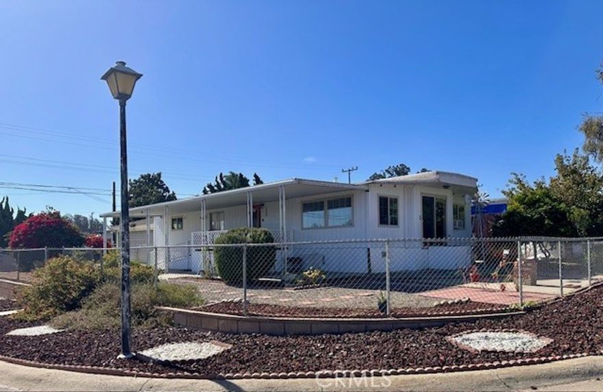 This is a vintage manufactured home, that was built in the early 1970s.  3 bedroom, 2 bath with a super large 2 car garage. Being that it's on a corner lot, it has two driveways, one on each side. It is fully gated. The property has recently been remodeled with all new PEX plumbing as well as new flooring in the living room, dining area, kitchen and the hallways. Lots of room. The kitchen has been remodeled. Great for a starter home in Nipomo.
You will not be able to get Conventional/FHA financing. However, there are mobile home Financing available from Murphy Bank, Mobile Homes.com and Community bank.  There is no HOA… You own the land