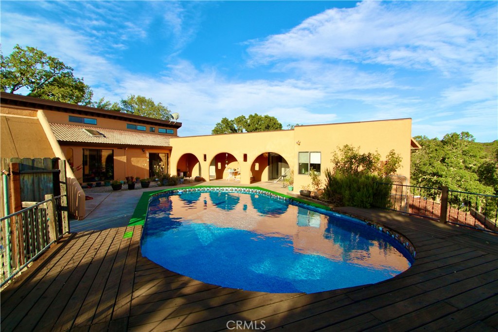 This 3 bedroom, 2 bath, 2200 sq.ft (per seller from original reports) Pueblo style charmer set on 3 1/3 acres embodies the quintessential character of the Southwest, offering a tranquil escape with modern comforts. Set prominently on a hill overlooking the Scotts Creek area & bordering a seasonal creek, this home is inspired by traditional Pueblo architecture. Boasting an exterior of smooth, rounded, earthly stucco walls but once you step inside, you will be welcomed by an open floor plan, high ceilings in the main living area, so much SPACE in this move in ready home and an abundance of natural light from multiple skylights and a clerestory windows. The well appointed kitchen just off the fully enclosed sun room entry area offers modern appliances and ample space for culinary creations. Featuring separate dining room and large living room with wood burning stove. Plenty of room in three ample bedrooms and two spacious bathroom areas. The main bathroom features dual sinks and separate tiled shower. Enjoy seamless outdoor living & evening sunsets with multiple access points leading to your very own private patio area complete with in-ground Doughboy pool, sunning and covered patio areas. Take in the unique Lake County wildlife and views of the Mayacamas Mountains from your deck and abundance of surrounding nature. There is even a seasonal creek on the Southside and wonderful scenic walks along Scotts Creek nearly and close to South Cow Mountain Recreation area. Freshly painted exterior, new paint in dining and living room areas. NEW water heater in garage and separate water heater for bedroom side of home. NEW north & south side retaining walls in place, new pool framing and liner. Central heat and air as well as a cozy wood burning stove. Marlin roof coating on flat roof areas over bedrooms and front of garage. Backside of garage features a new torch-down rolled roofing which is an ideal sunny location for future solar (no solar currently in place). Country living just got a whole lot nicer. Zoned RR, this would make a perfect homestead. Updated electrical and water available near shed by well housing. Just minutes from downtown and the lake, you'll feel like you stepped into paradise. Experience all the affordability and friendliness of Lake County CA. Buyer to verify all lot lines, utilities and square footage.