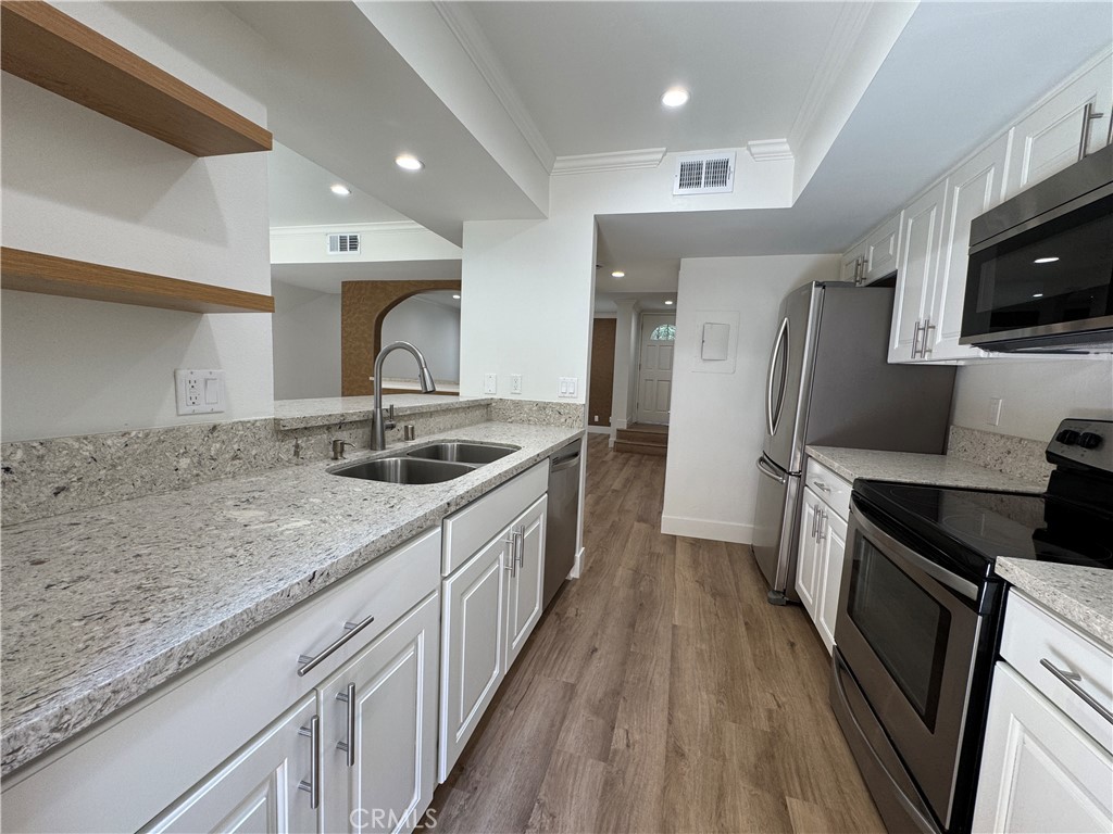 Welcome to 4059 Yankee Drive, a beautifully updated 3-bedroom, 1.5-bathroom townhome in the highly sought-after Liberty Canyon community of Agoura Hills. This two-story home features all-new luxury vinyl plank (LVP) flooring throughout, including the stairs, for a clean and modern look. The renovated kitchen boasts granite countertops, stainless steel appliances—including a built-in refrigerator, dishwasher, and electric oven range—and ample cabinet space, making it both stylish and functional. Both the upstairs bathroom and main-level powder room have been tastefully remodeled with modern finishes. The home is enhanced with energy-efficient LED recessed lighting and updated fixtures throughout, creating a bright and inviting atmosphere. Vinyl blinds and custom window coverings add privacy and style to every room. The open layout includes a bright living and dining area, and upstairs you'll find three bedrooms, including a primary suite with a spacious walk-in closet and a custom accent wall, plus generous hallway storage. Enjoy outdoor living in the private patio area, perfect for dining or relaxing. Additional features include central heating and air, dual-pane windows, and two detached carport spaces with built-in storage. Low HOA dues include access to a community pool and Jacuzzi, as well as an onsite laundry facility. Located in the historic Quarter of Agoura Hills within the award-winning Las Virgenes Unified School District, this home offers convenient proximity to the 101 Freeway, world-class shopping, dining including the historic Blue Star Playhouse, and is just a short drive to the Malibu beaches. Experience the perfect blend of comfort, style, and location!